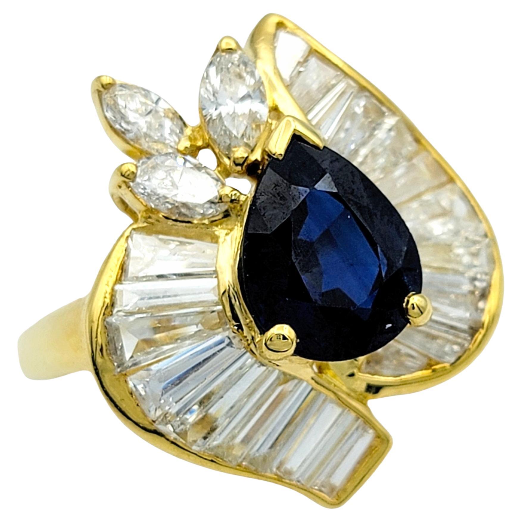 Ring Size: 7.25

This exquisite ring features a captivating pear-shaped blue sapphire as its focal point, exuding a deep and mesmerizing hue. Encircling the sapphire is a halo of shimmering diamonds, meticulously arranged in an asymmetrical pattern