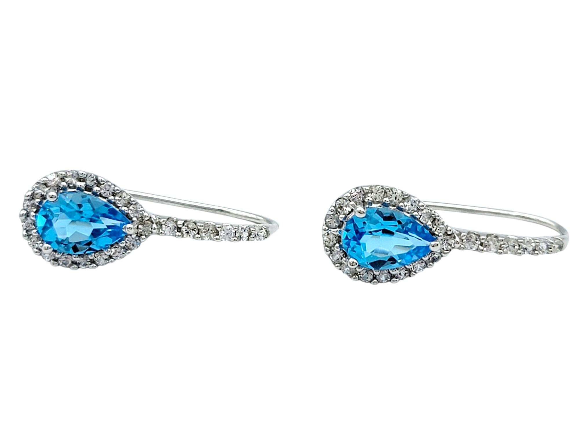 Contemporary Pear Cut Blue Topaz and White Sapphire Halo Drop Earrings in 14 Karat White Gold For Sale