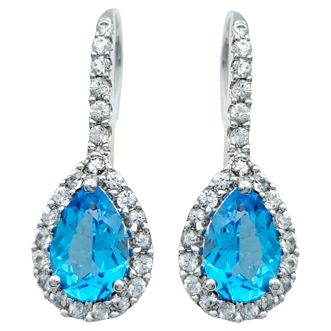 Pendientes de gota con halo de topacio azul talla pera y zafiro blanco en oro blanco de 14 quilates