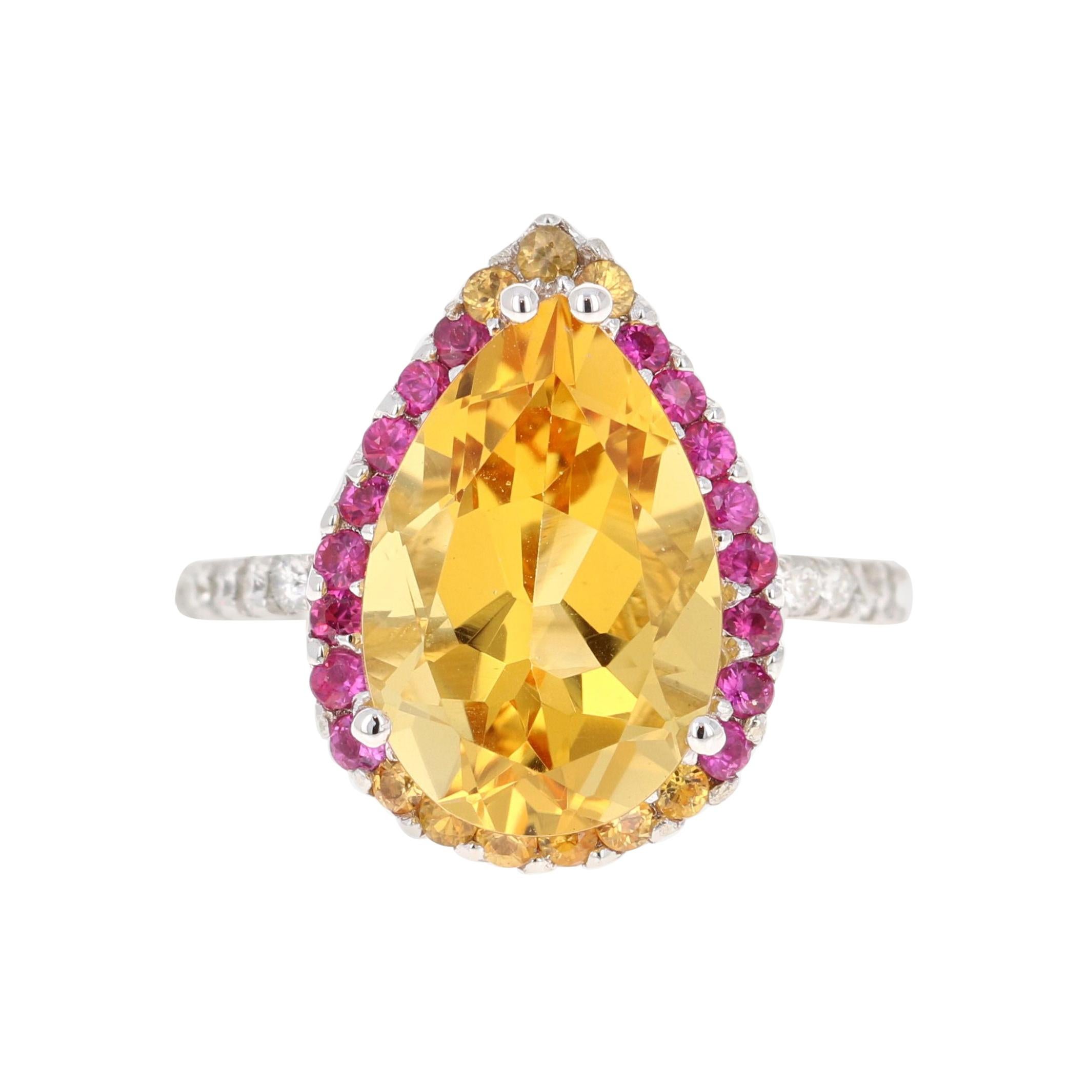 This gorgeous ring has a magnificent Pear Cut Citrine Quartz weighing 5.28 Carats and is surrounded by 25 Pink and Yellow Sapphires that weigh 0.60 carats and 20 Round Cut Diamonds that weigh 0.37 carats. (Clarity: SI, Color: F) The total carat