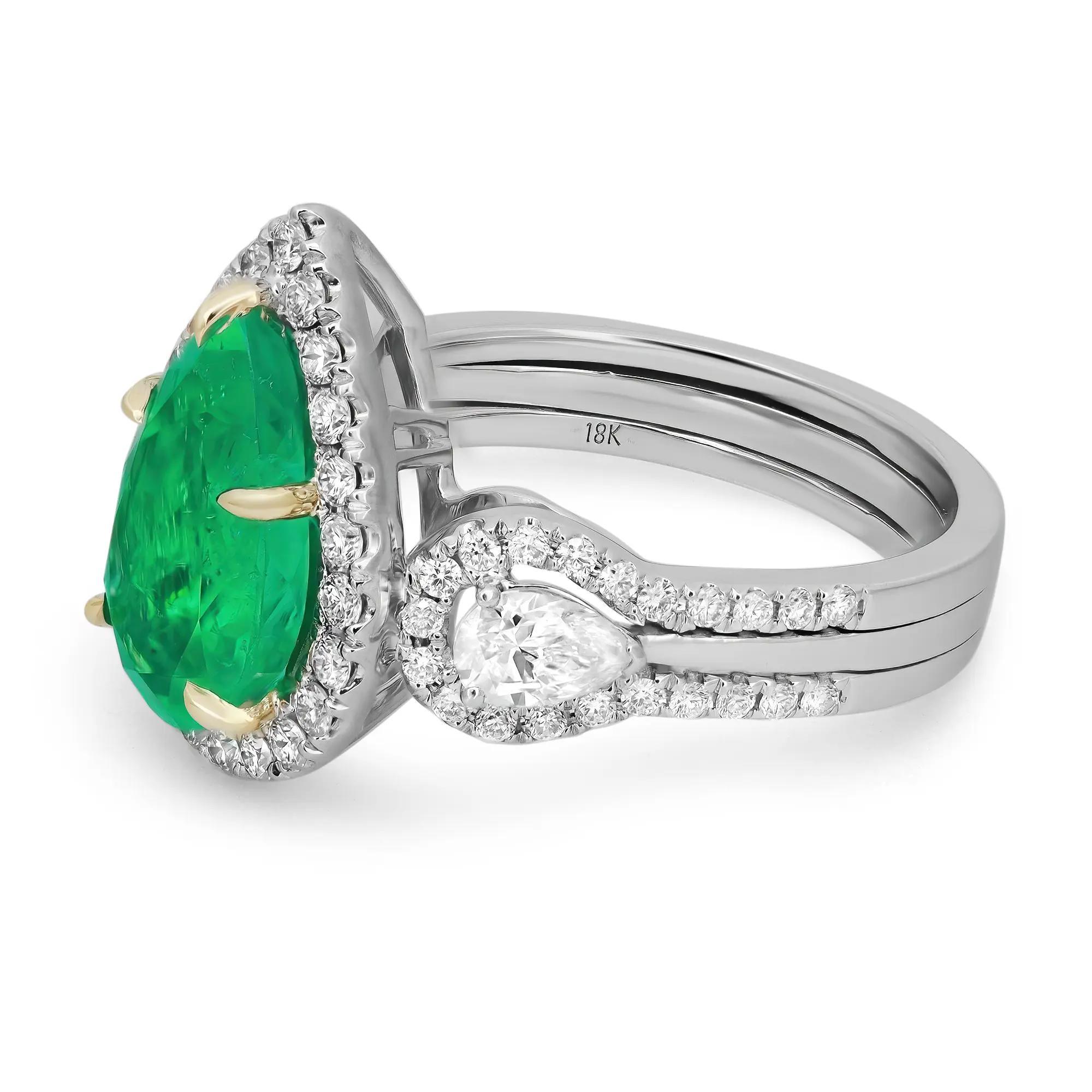 Wrap your finger with this extraordinary ring showcasing a GIA certified prong set pear cut rich green Colombian Emerald weighing 2.60 carats surrounded by a halo of round brilliant cut diamonds with two prong set pear cut diamonds on each side