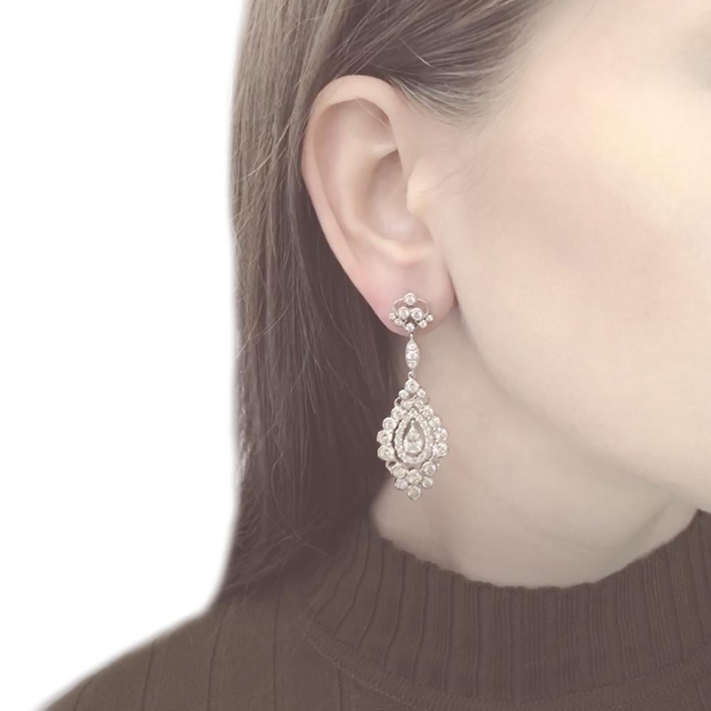 This dainty drop earrings holds center pear cut diamonds 1.12 carat total.
Accented by round cut white diamonds 6.32 ct.
Diamonds are natural in G-H Color Clarity VS. 
Platinum 950 metal. 
Butterfly studs. 
Floral inspired design.
Width: 1.8