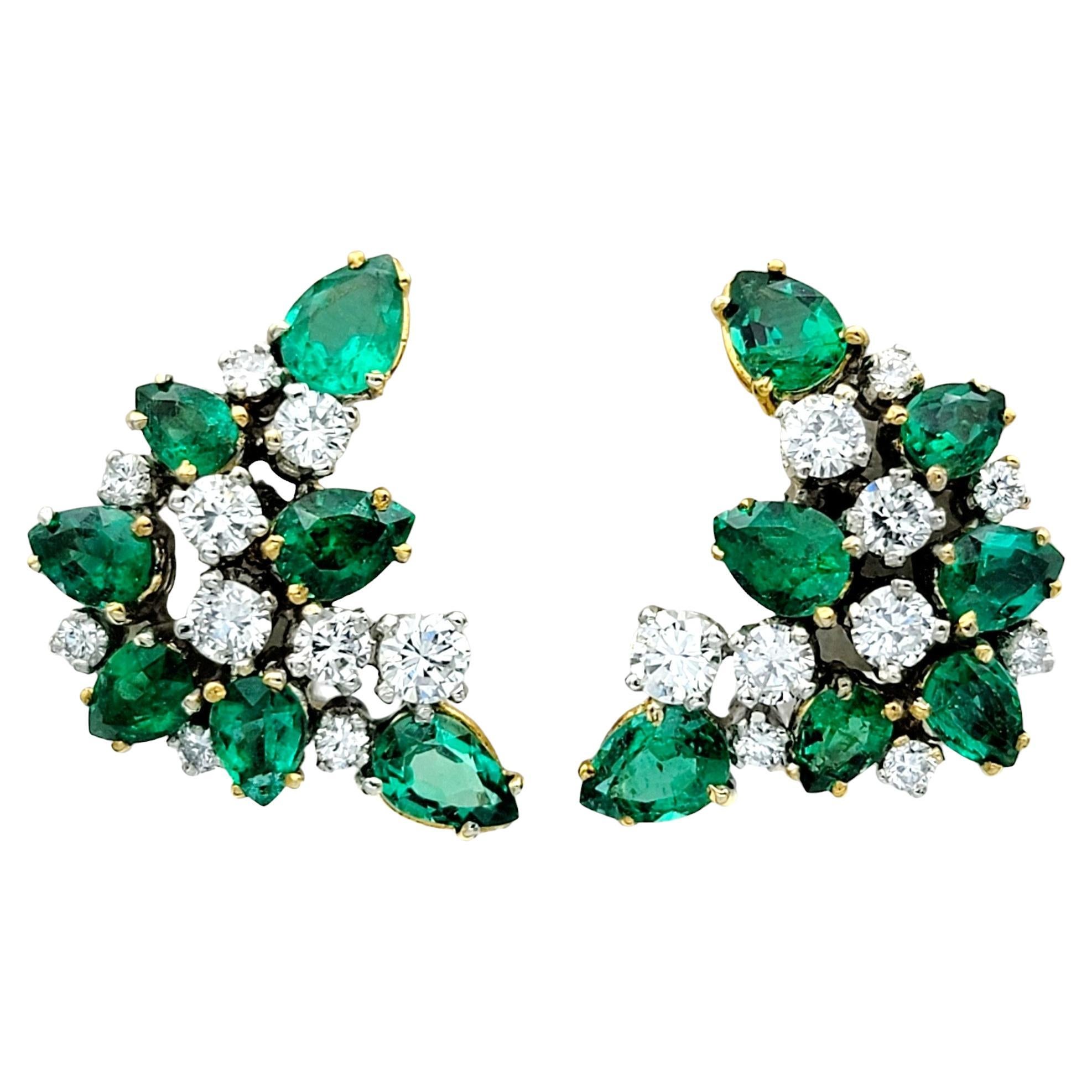 These gorgeous emerald and diamond cluster earrings are crafted in radiant 18 karat yellow gold. Each earring features a captivating cluster of vivid green pear cut emeralds paired with dazzling round diamonds, creating a mesmerizing display of
