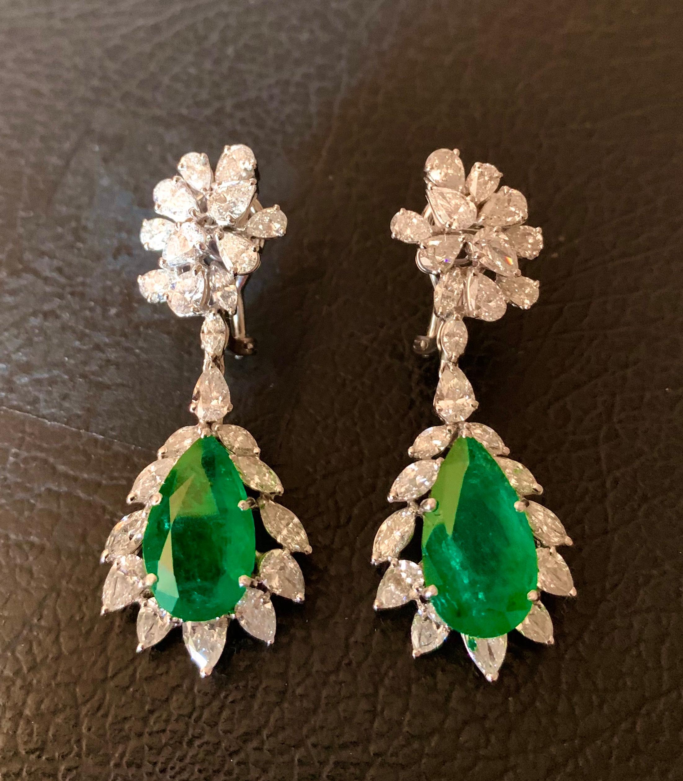 Long earrings in a modern classic style with a pair of pear cut emeralds and fantasy cut, pear and marquise cut diamonds.The emeralds are natural and are of 