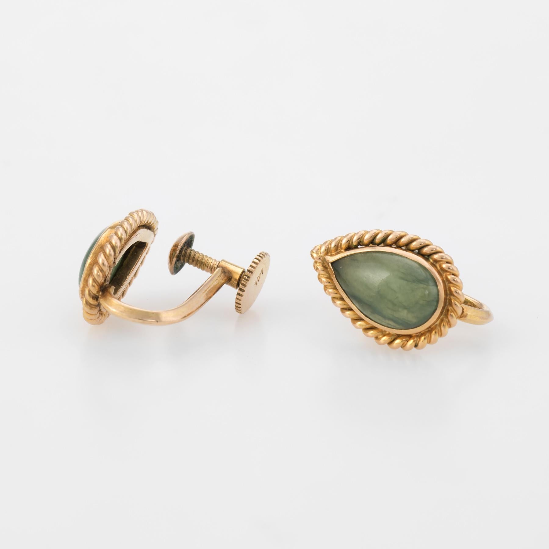 Finely detailed pair of vintage jade earrings (circa 1950s to 1960s), crafted in 14k yellow gold. 

Cabochon cut jade measures 10mm x 6mm (estimated at 1.50 carats each - 3 carats total estimated weight). The jade is in excellent condition and free