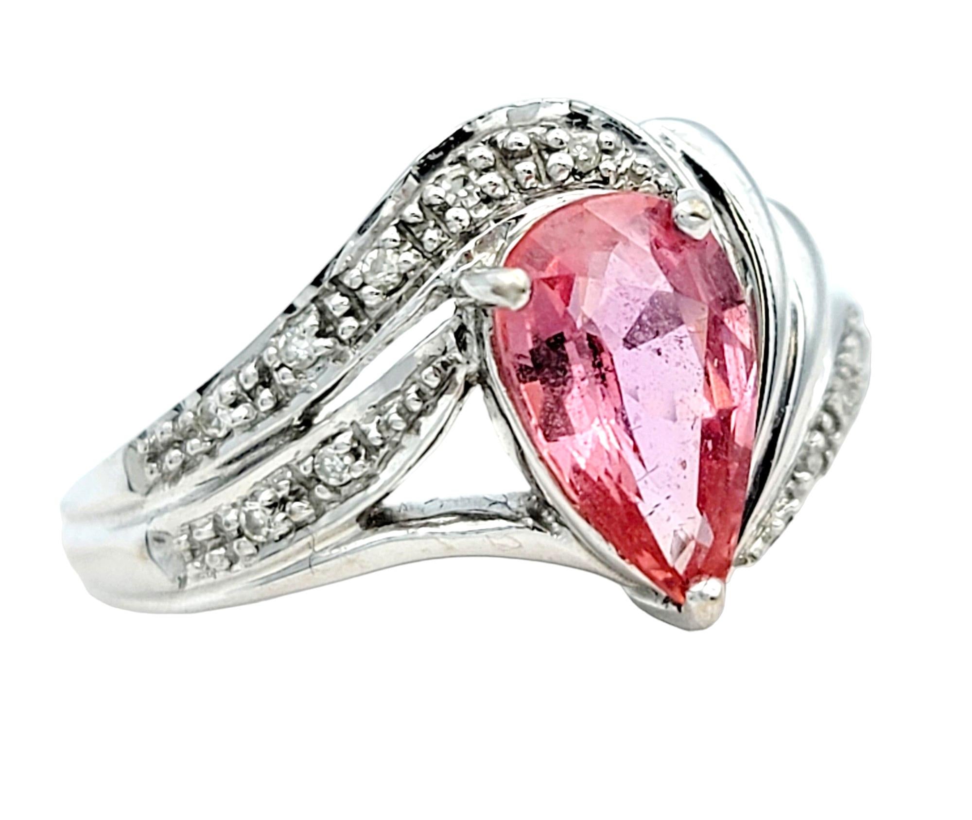 Ring Size: 7

The rare and exquisite beauty of this padparadscha sapphire and diamond ring is a captivating masterpiece set in luxurious 18 karat white gold. At the heart of the design sits a pear-shaped padparadscha sapphire, known for its stunning
