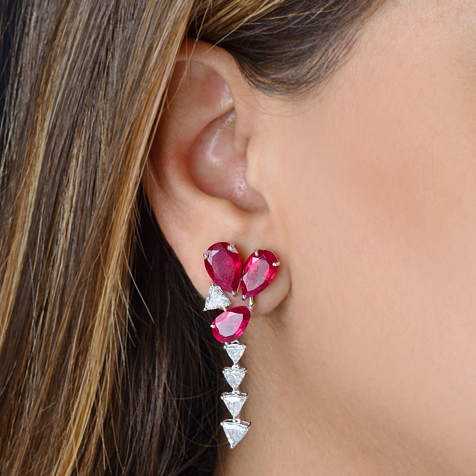 Boucles d'oreilles pendantes en or blanc 14K avec diamants et pierres rouges taillées en poire.
Ce bijou a été conçu de façon magistrale avec une pierre précieuse rouge riche et des diamants blancs dans un mélange artistique de coupes poire et
