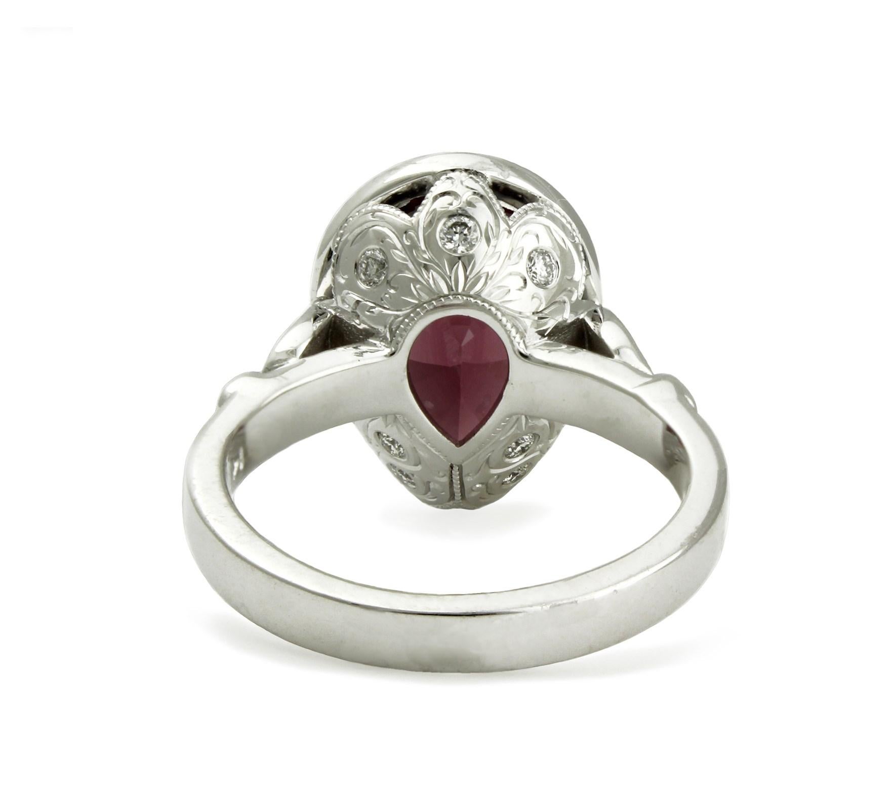 6.98ct pear-cut Rhodolite Garnet gem bezel set in 14kt white gold. Hand engraved on the under-gallery and set with 12 diamonds equal 0.25ct total. Size 6 1/2. Resizing up or down 2 sizes included in price.