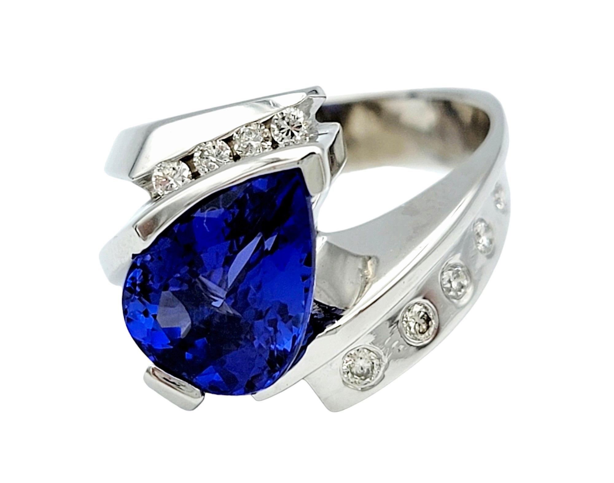 Misura dell'anello: 7,75 

Questo squisito anello ha come centro una splendida tanzanite a forma di pera, che emana eleganza e fascino con la sua ipnotica tonalità blu-viola. Incastonata all'interno di un grazioso design a bypass realizzato in