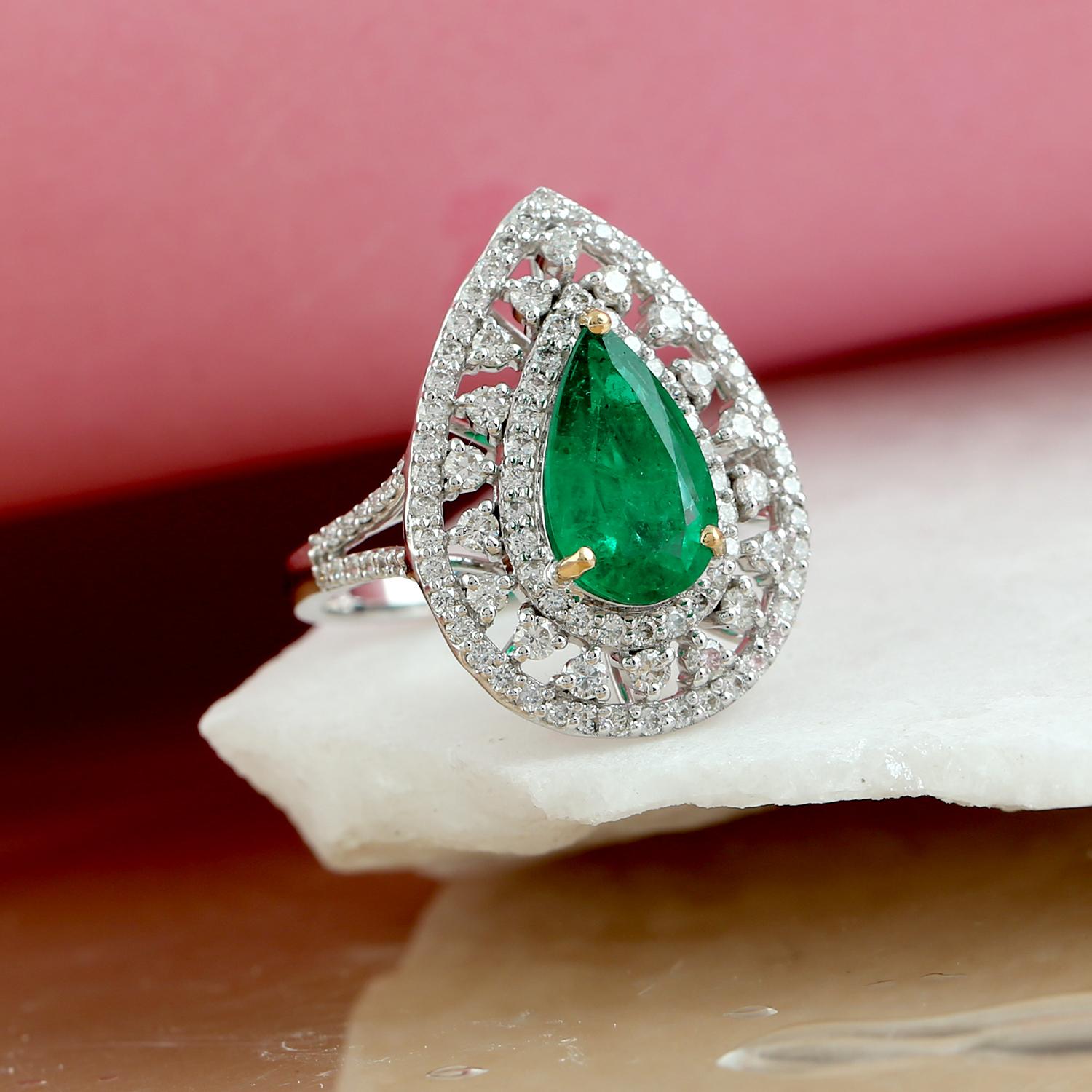 This Pear Drop Shaped Green Emerald Ring is a stunning piece of jewelry that is sure to capture attention. The focal point of the ring is a pear-shaped green emerald that is beautifully faceted and set in 18k white gold. Surrounding the emerald is a