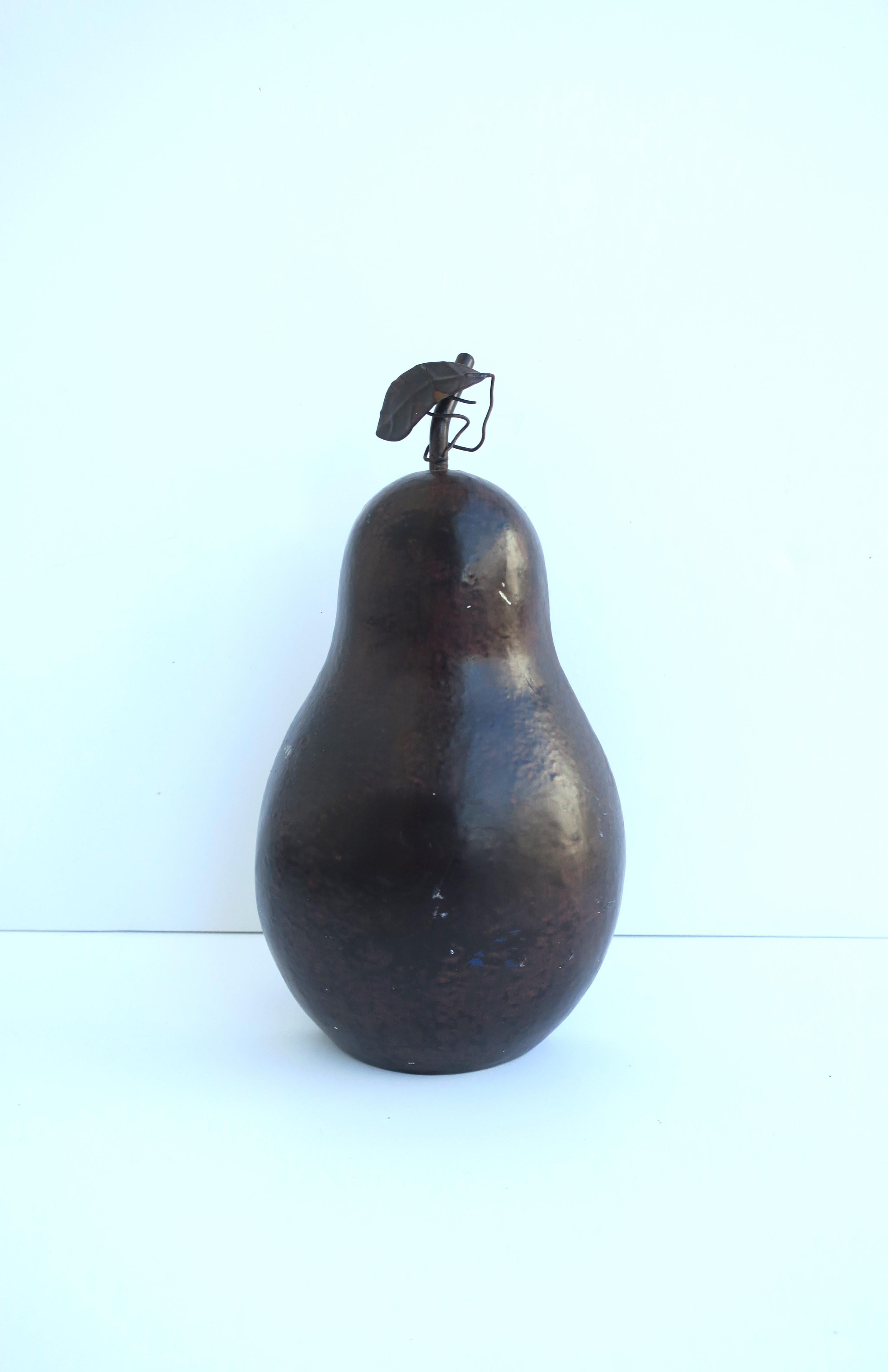 A cast iron pear fruit doorstop, (door stop, doorstopper), with a dark brown enamel surface and leaf detail, circa mid-20th century. Dimensions: 8.25