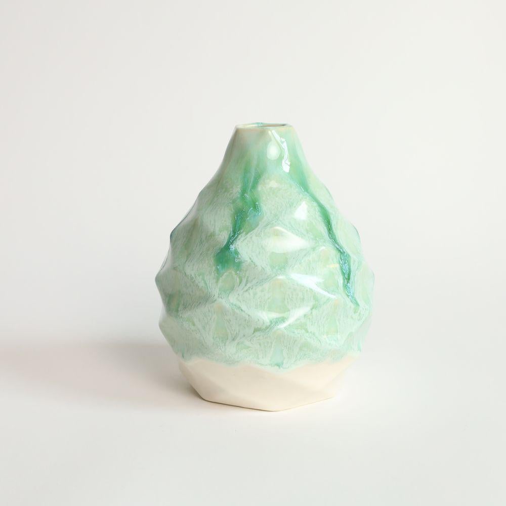 Pear in Jade
The Patterned Vessel Pear is a stunning decorative piece inspired by the delicious and juicy fruit for which it is named. This exquisite vase boasts a unique hexagonal profile that narrows to a slender neck, giving it an irresistible