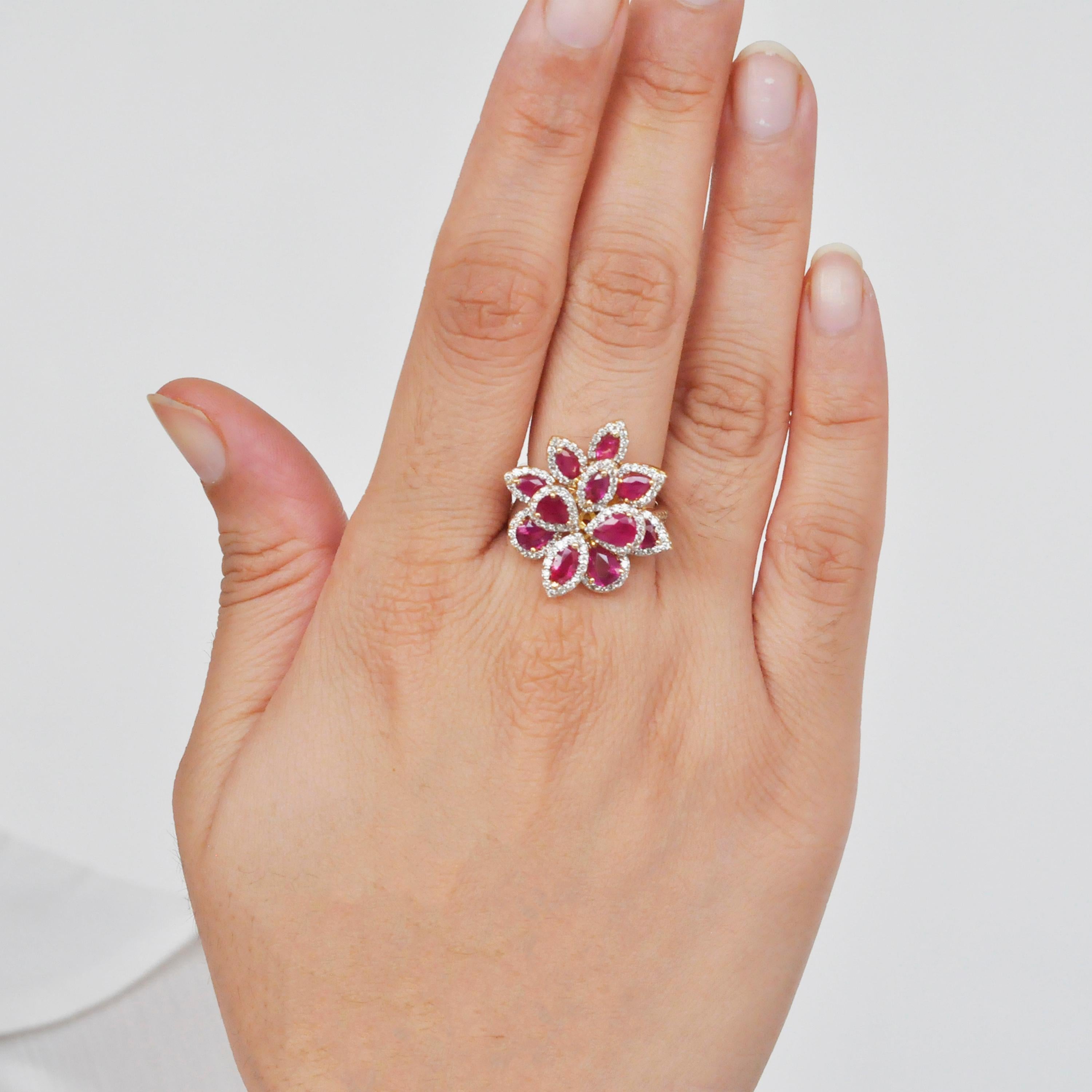 18 karat yellow gold pear marquise ruby flower diamond cocktail ring. 

This enchanting red ruby and diamond flower cocktail ring is impressive. The cluster is created with
alternating pear and marquise shaped red rubies along with sparkling VVS/VS