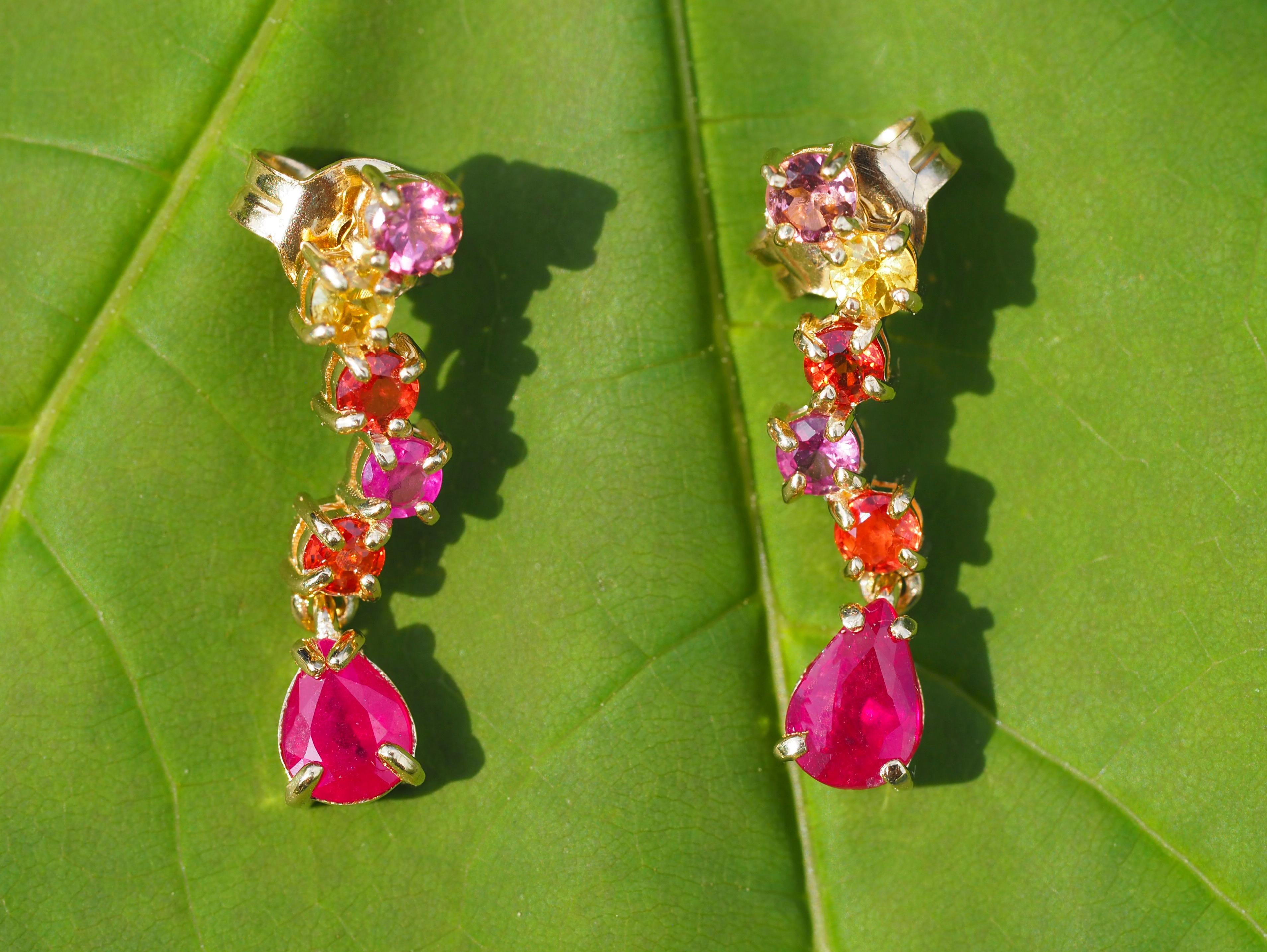 Pear ruby 14k gold earrings studs. 
Red, pink, orange and yellow sapphire studs. Colorfull gold earrings. Ruby earrings studs.

Total weight: 2.30 g.
Metal: 14k gold.
Size: 20 x 5 mm.

Central stones: Rubies - 2 pieces
Cut: Pear
Weight: approx 1.2