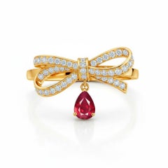 Pear ruby drop bow ring in 14k gold