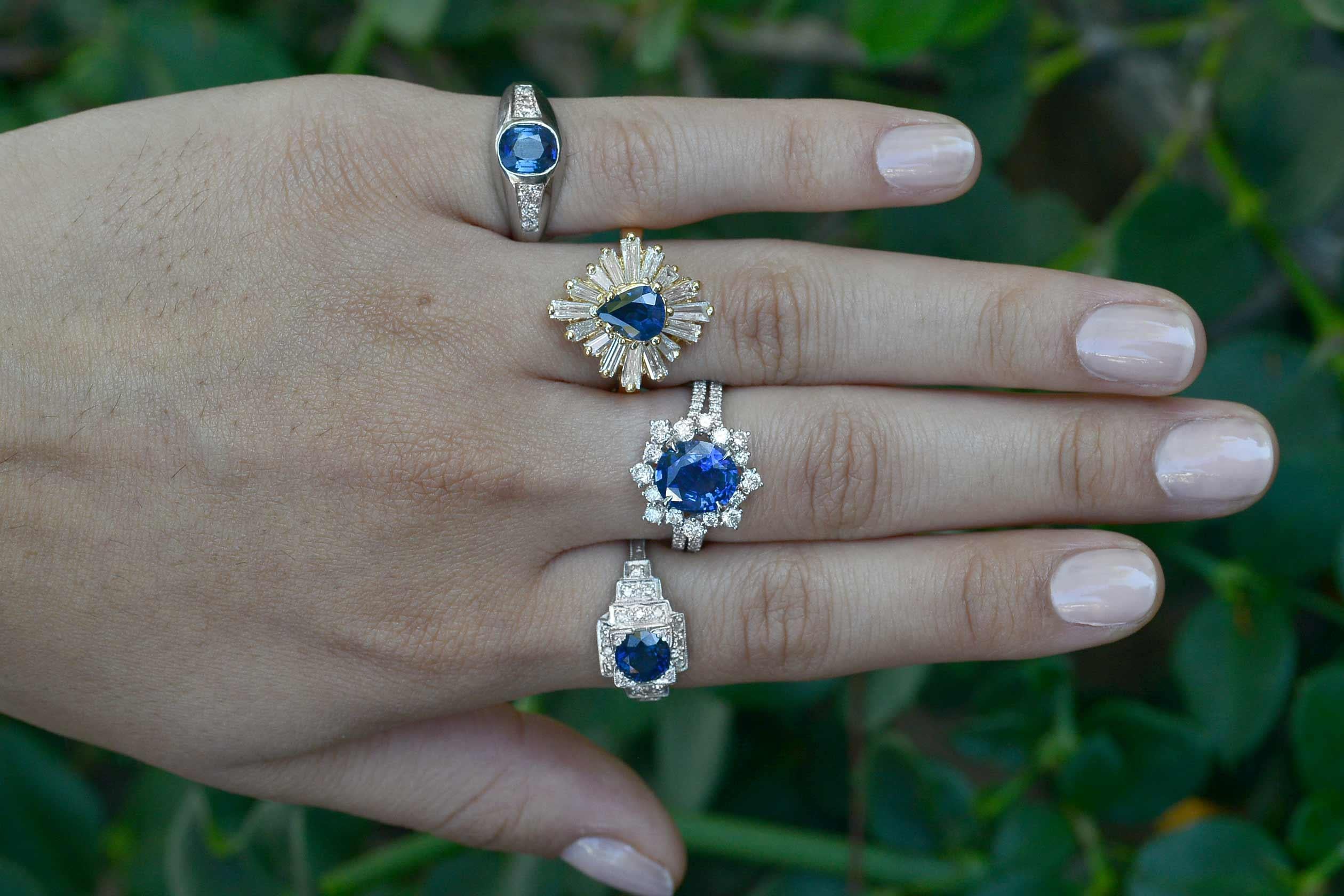 The Waco Ballerina Cocktail Ring. A velvety, vibrant and lustrous pear shape blue sapphire that commands your attention. Expertly crafted of 18k yellow gold in a flower cluster featuring an undulating row of shimmering baguette diamonds that
