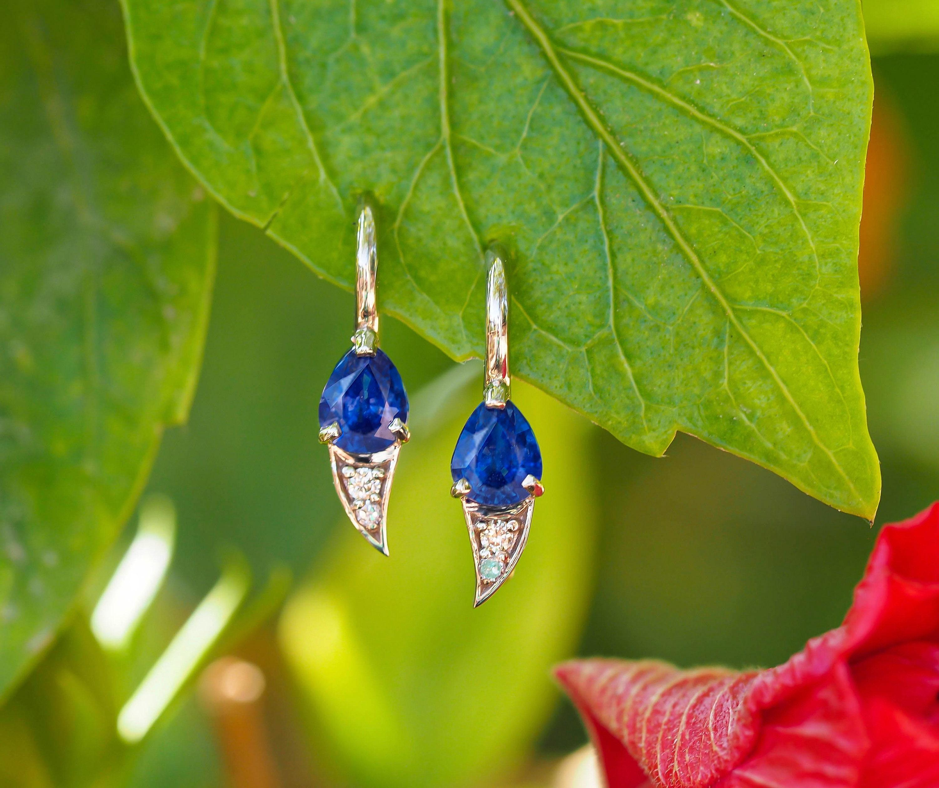 Genuine 1.5 ct sapphire earrings in 925 silver.

Metal: 925 silver
Weight: 1.5 g.
Size: 14.5x4.5mm

Central stones:
Sapphires, 2 pieces, pear cut, intence blue color, transparent with inclusions, 1 ct total (0.5 ct each)

Side stones:
Diamonds -