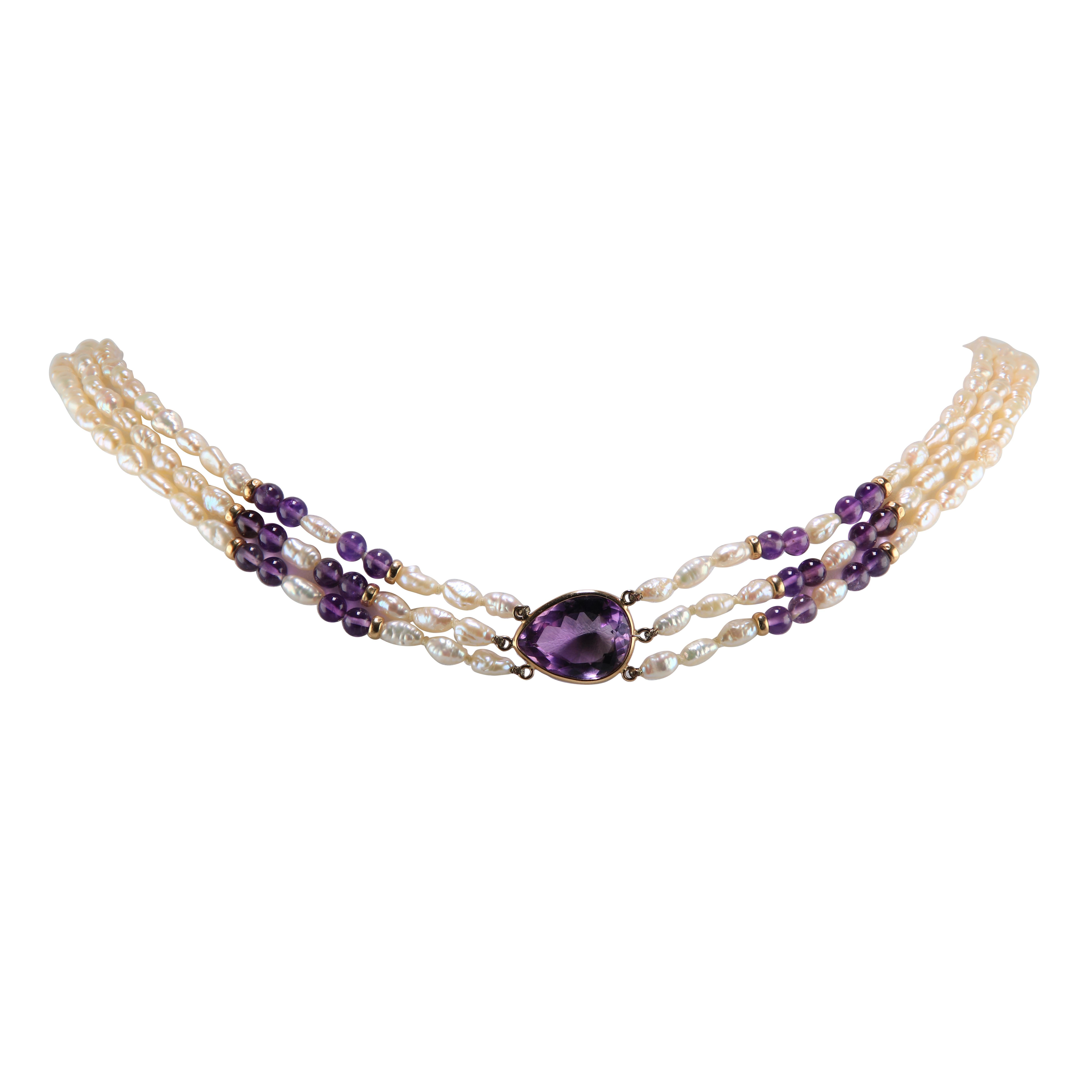 Pear Shape Amethyst 14 Karat Freshwater Seed Pearl Necklace
Sophisticated 14k gold Amethyst necklace with three strands of baroque freshwater seed pearls. This necklace has a pear shape 20 mm x 16 mm Amethyst as the main amulet of the piece. The