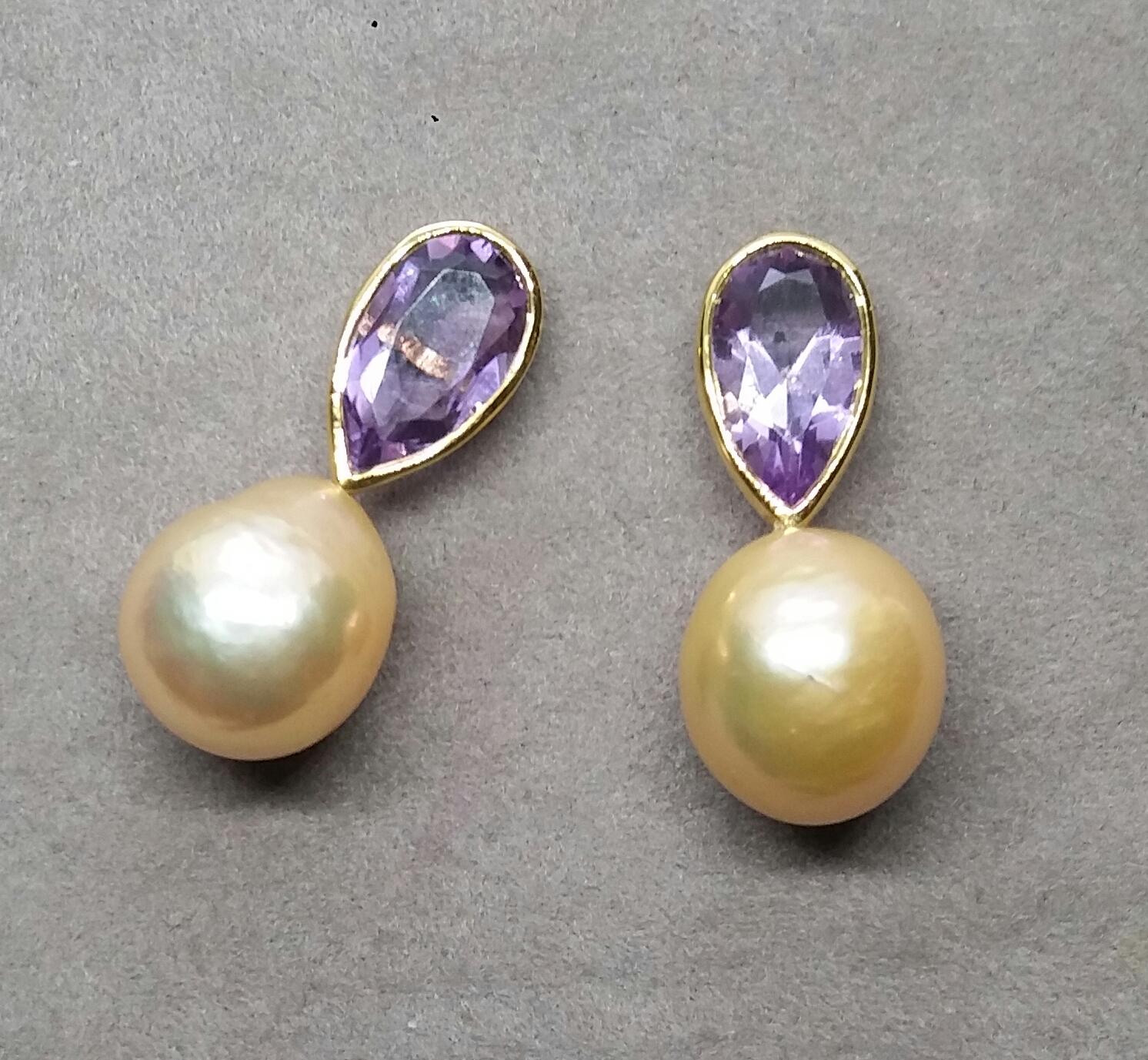  Ces boucles d'oreilles simples mais élégantes, entièrement faites à la main, sont composées de 2 améthystes naturelles en forme de poire à facettes mesurant 7x12 mm, serties dans un chaton en or jaune au sommet duquel sont suspendus 2  Perles