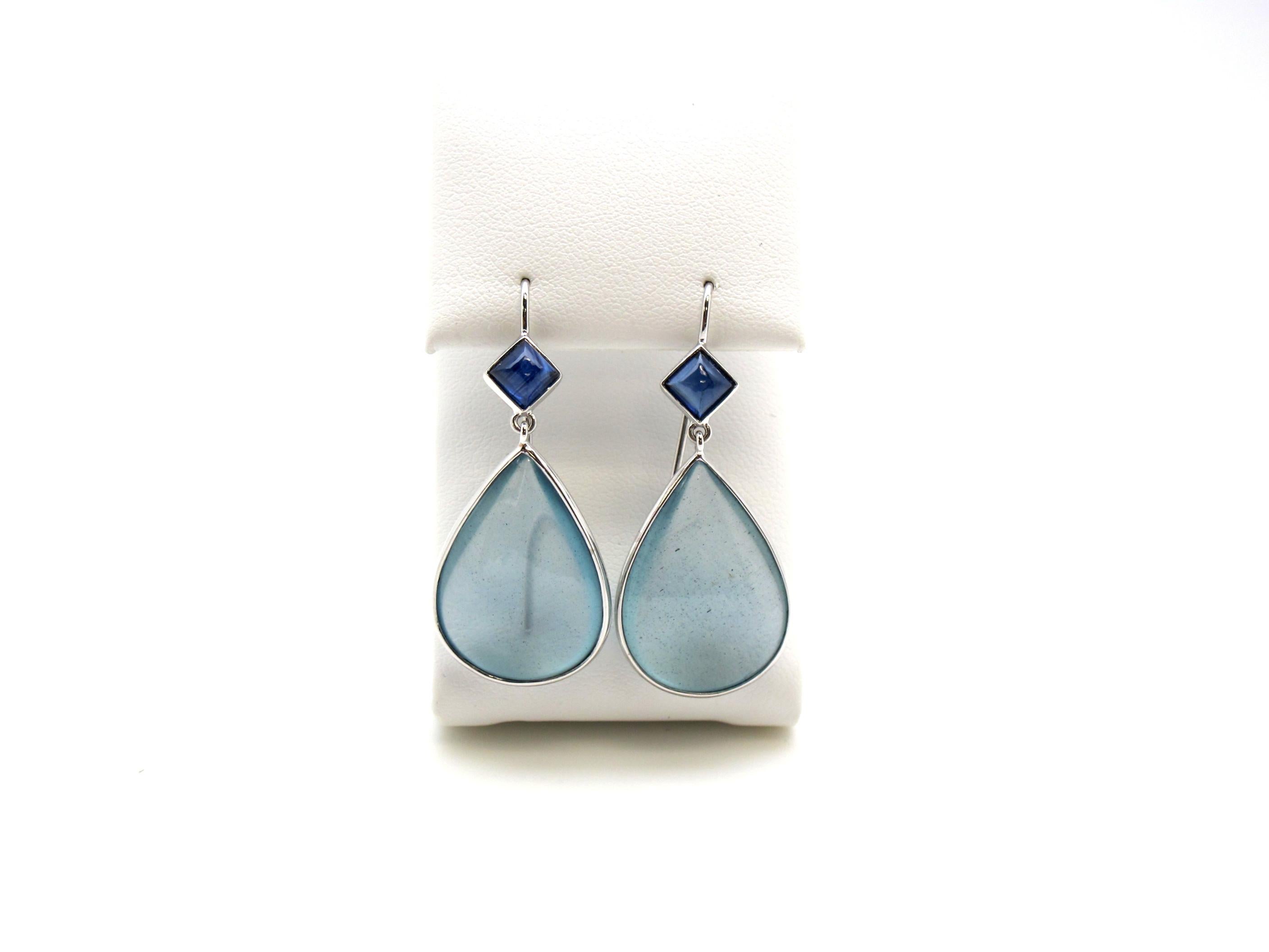 Unusually large aquamarine pendaloques are masterfully paired with blue sapphires to form these beautiful earrings.   The earrings are handmade of 18K white gold, two pear shaped aquamarines (30.26cts/tw) and two princess cut sapphire cabochons
