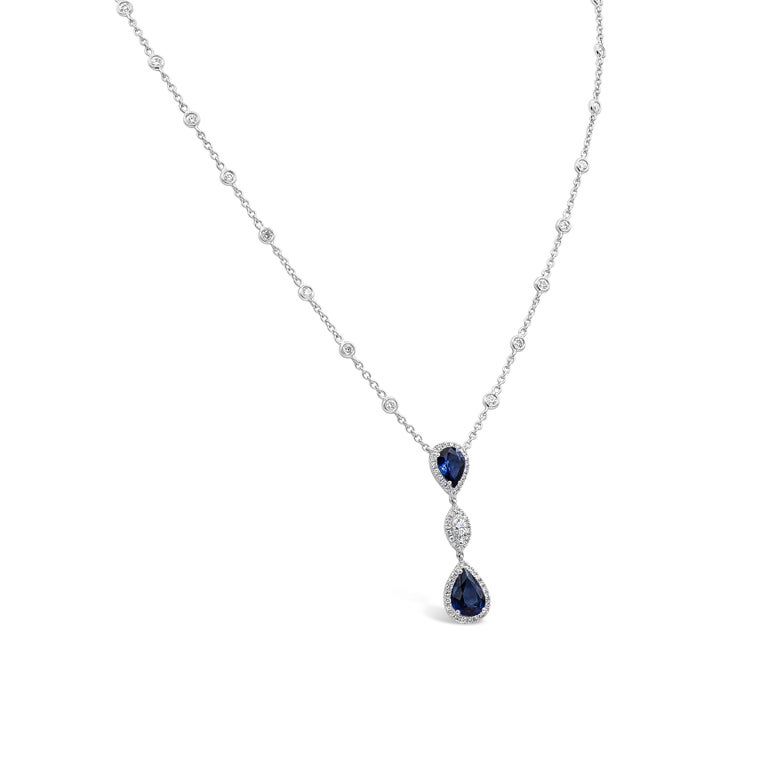 Showcasing a beautiful pear shape blue sapphire, surrounded by a single row of round brilliant diamonds. Each sapphire halo is suspended on a pear shape halo and marquise cut halo. Attached to a chic diamonds by the yard chain. Sapphires weigh 2.79