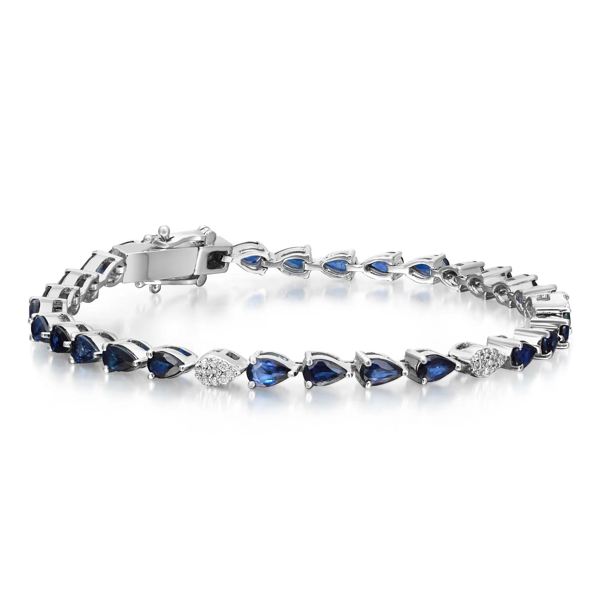 Faites rimer désir et style avec ce bracelet de tennis en saphir bleu et diamants, d'une facture exquise. Fabriqué en or blanc 14K. Ce magnifique bracelet comporte 29 saphirs bleus en forme de poire, sertis sur une tige, et trois diamants ronds en