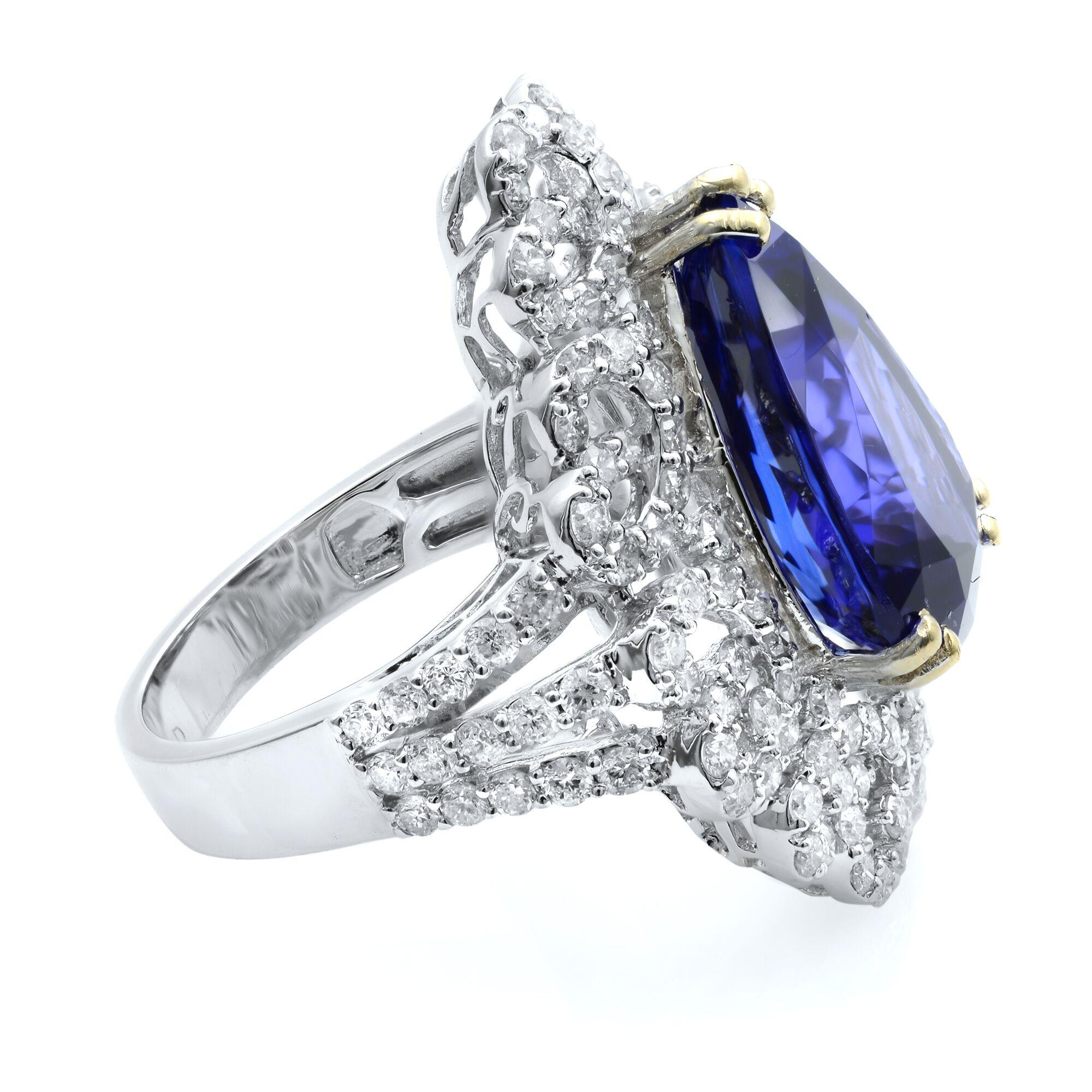 A large (8.20 carat) and luscious, vibrant ocean blue, faceted pear cut tanzanite glistens and glows from within a sizable sizzling whimsical halo composed of no less than 2.10 carats of bright white and sparkling round brilliant-cut diamonds.