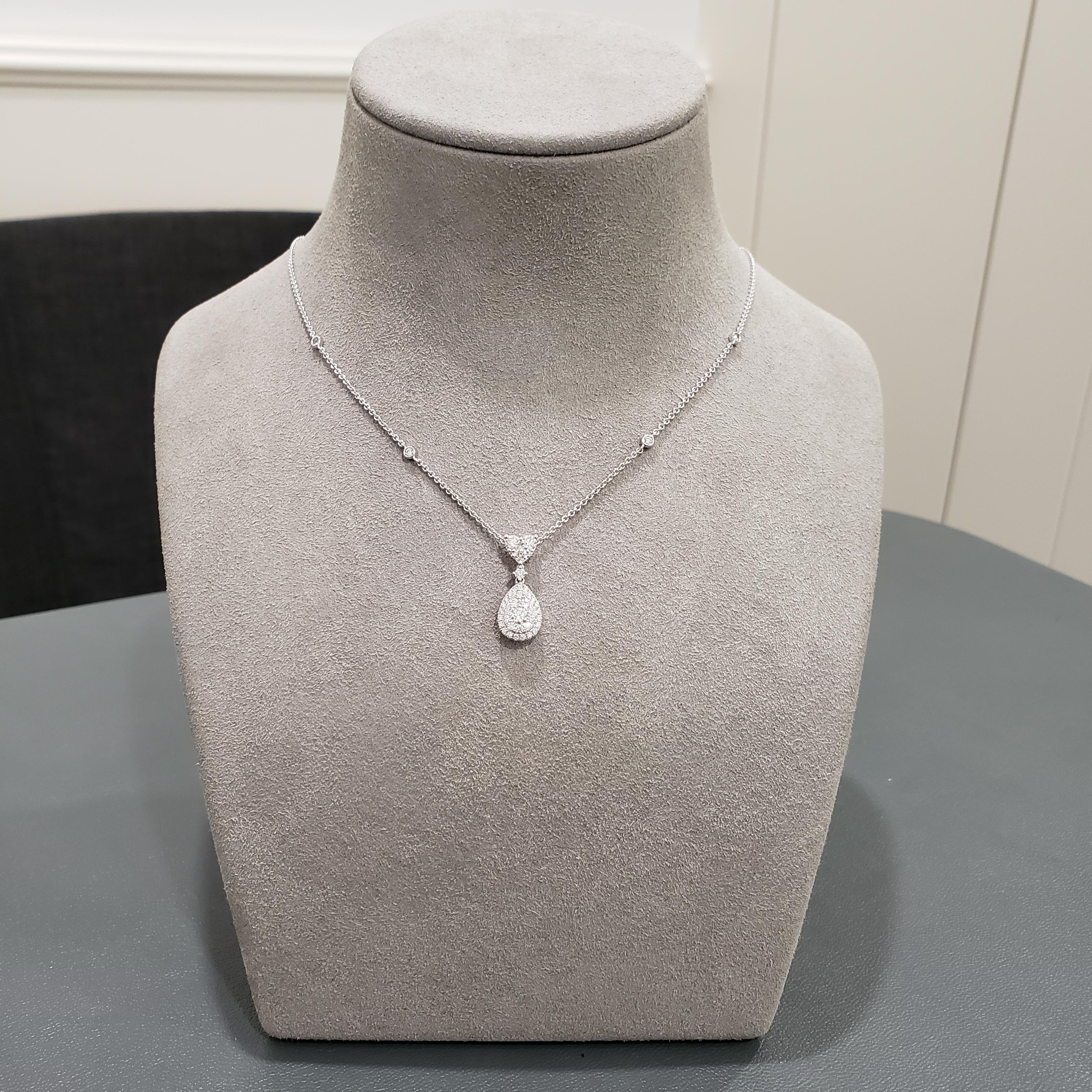 A simple illusion pendant necklace showcasing a cluster of round brilliant diamonds, set in a pear shape design. Suspended in a diamonds by the yard chain. Diamonds weigh 0.89 carats total. Made in 18 karat white gold. 

