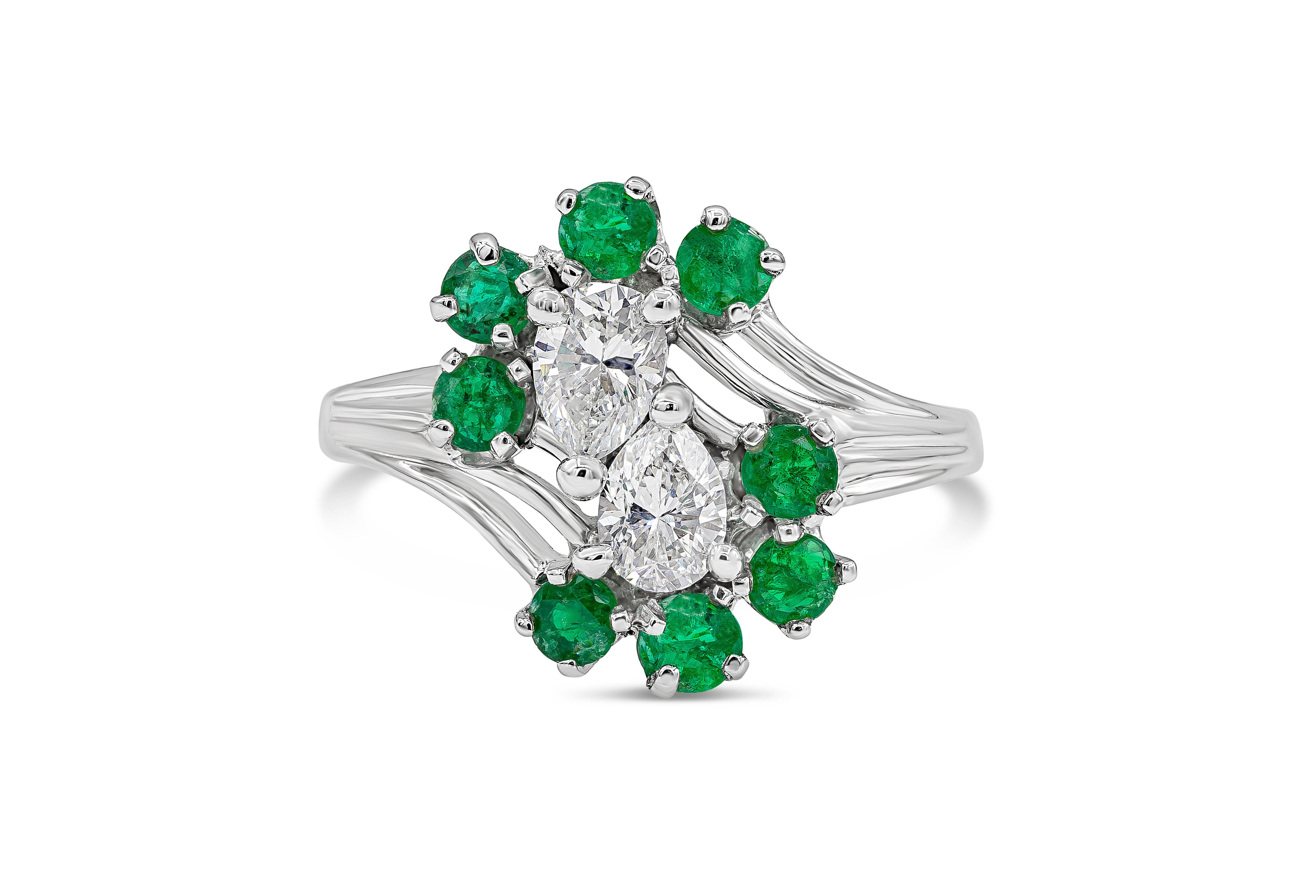 A vintage fashion ring showcasing two pear shape diamonds facing opposite each other accented by eight color-rich round cut green emeralds weighing 0.55 carats total. Diamonds weighs 0.50 carats total, FG color and VS-SI in clarity. Stones are set
