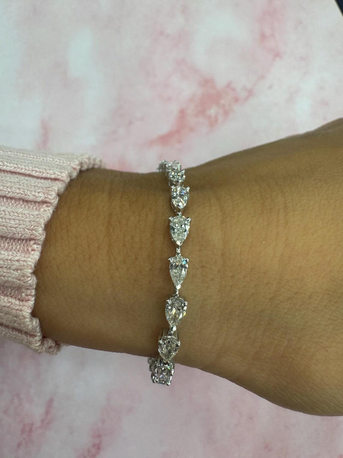 14 Karat white gold diamond tennis bracelet featuring 30 Pear shape diamonds weighing a total of 6.38 carats, average stone 0.20 points each.
Color H
Clarity VS2-SI1
