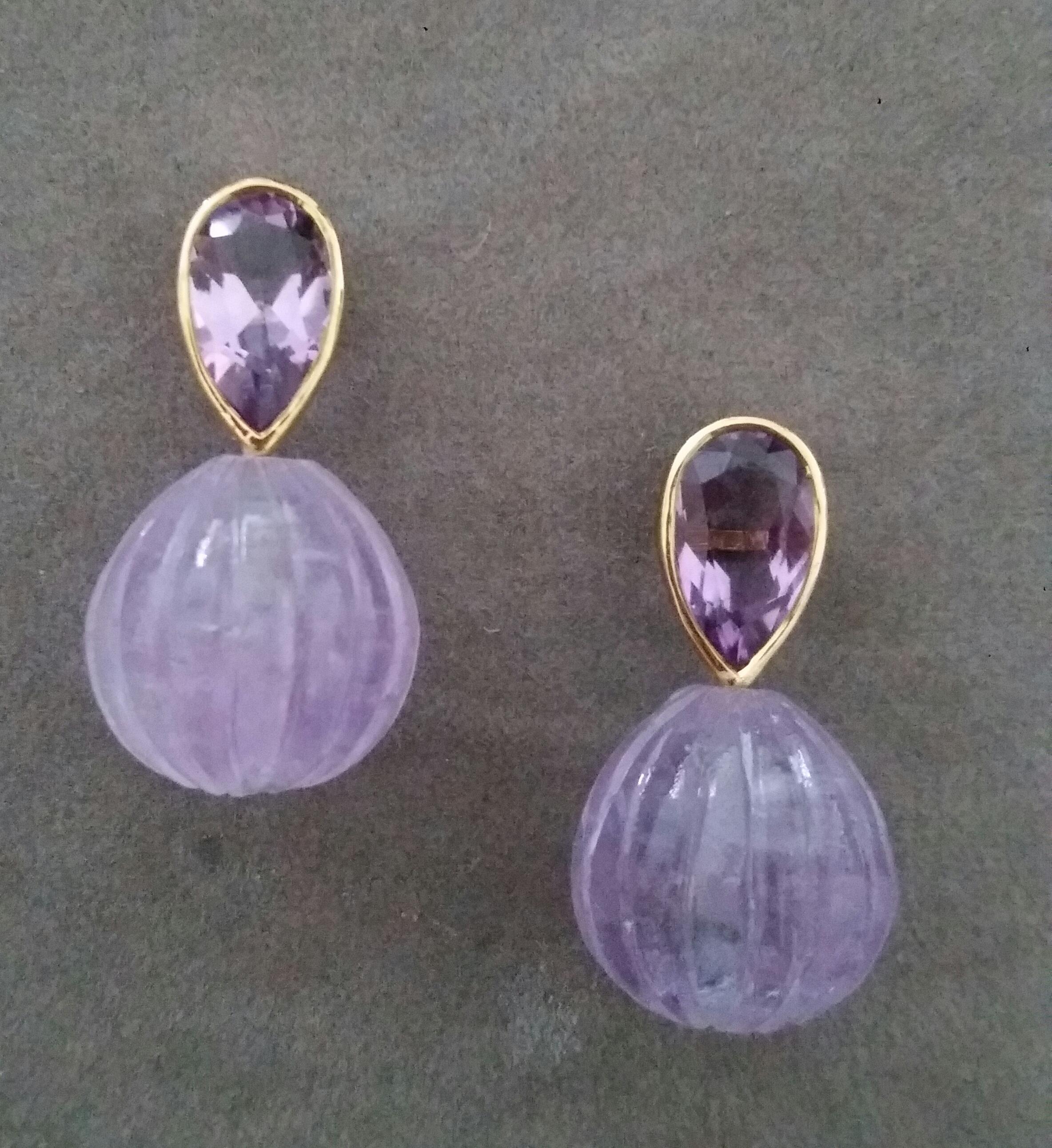 These simple but elegant handmade earrings have 2 faceted Natural Pear Shape Amethysts measuring 7 x 12 mm and weighing 4,55 carats set in yellow gold bezel at the top to which are suspended 2 Engraved Round Drop Shape Amethyst measuring 15x15
