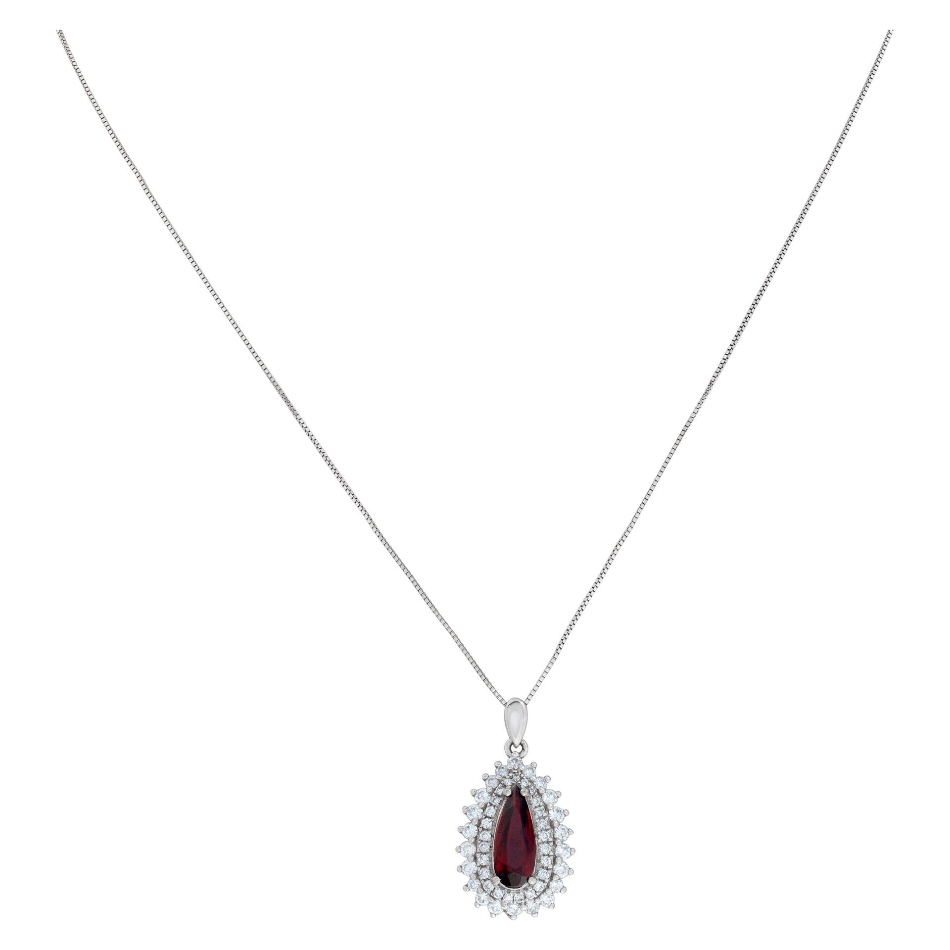 Pear shape Garnet pendant surrounded by diamonds set with approximately 0.79 carats in diamonds in 18K white gold with 16