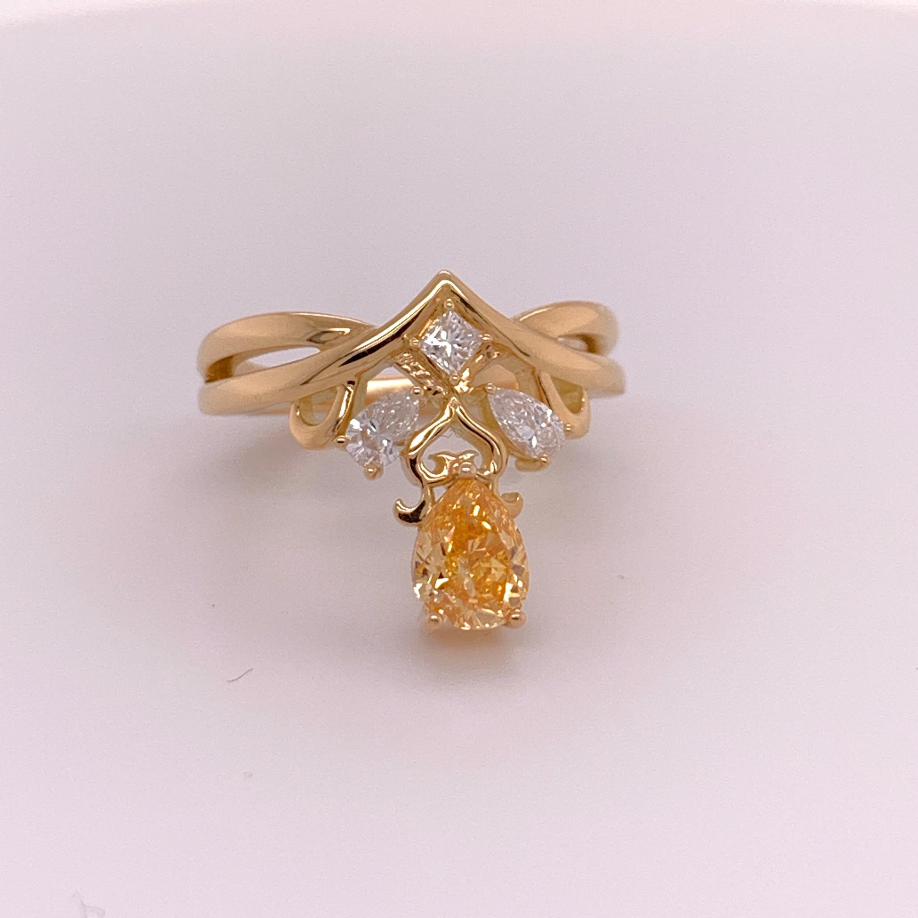 An 18k yellow gold ring set with a GIA certified 0.70ct Pear Shape SI1 Fancy Intense yellowish Orange as well as two pear shaped colorless diamonds and a princess cut weighing approximately 0.45 carats. 

Total weight is 1.15 carat.