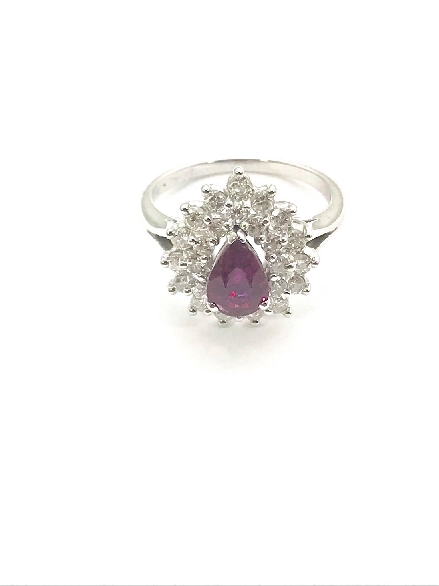 A pear shape natural ruby and round brilliant diamond 14 karat white gold ring.  The ruby is 0.76 carats, set with three prongs, surrounded by a double row of tiered round diamonds.  There are 27 round diamonds with a total weight of 0.75 carats,
