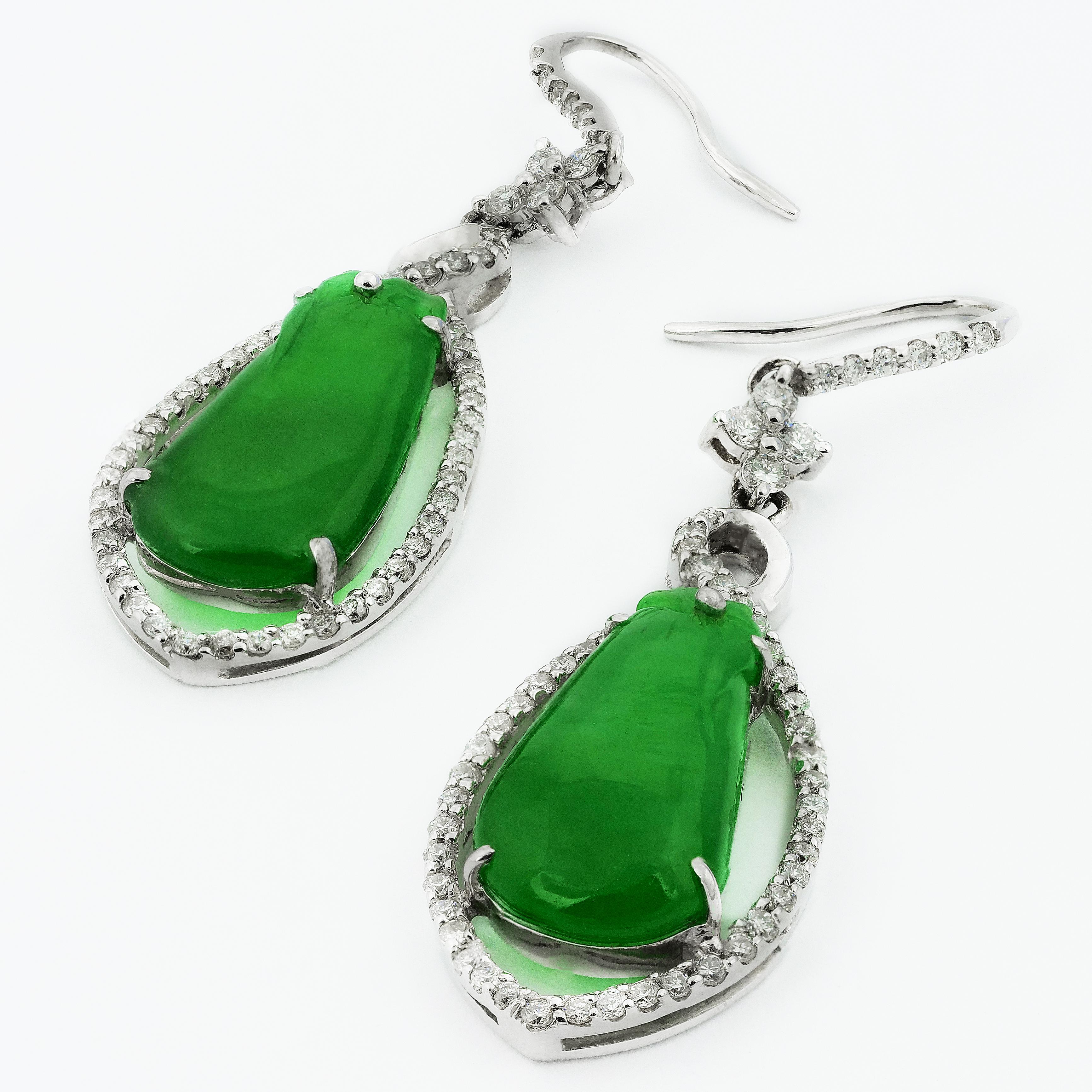 Stunning jade earrings in pear shape dangled by various shapes of crosses, circles and vertical lines all covered in glistening diamonds. The jade is calm and cooling and has a gorgeous sheer glowing sheen on it as well as subtle shades of greens.