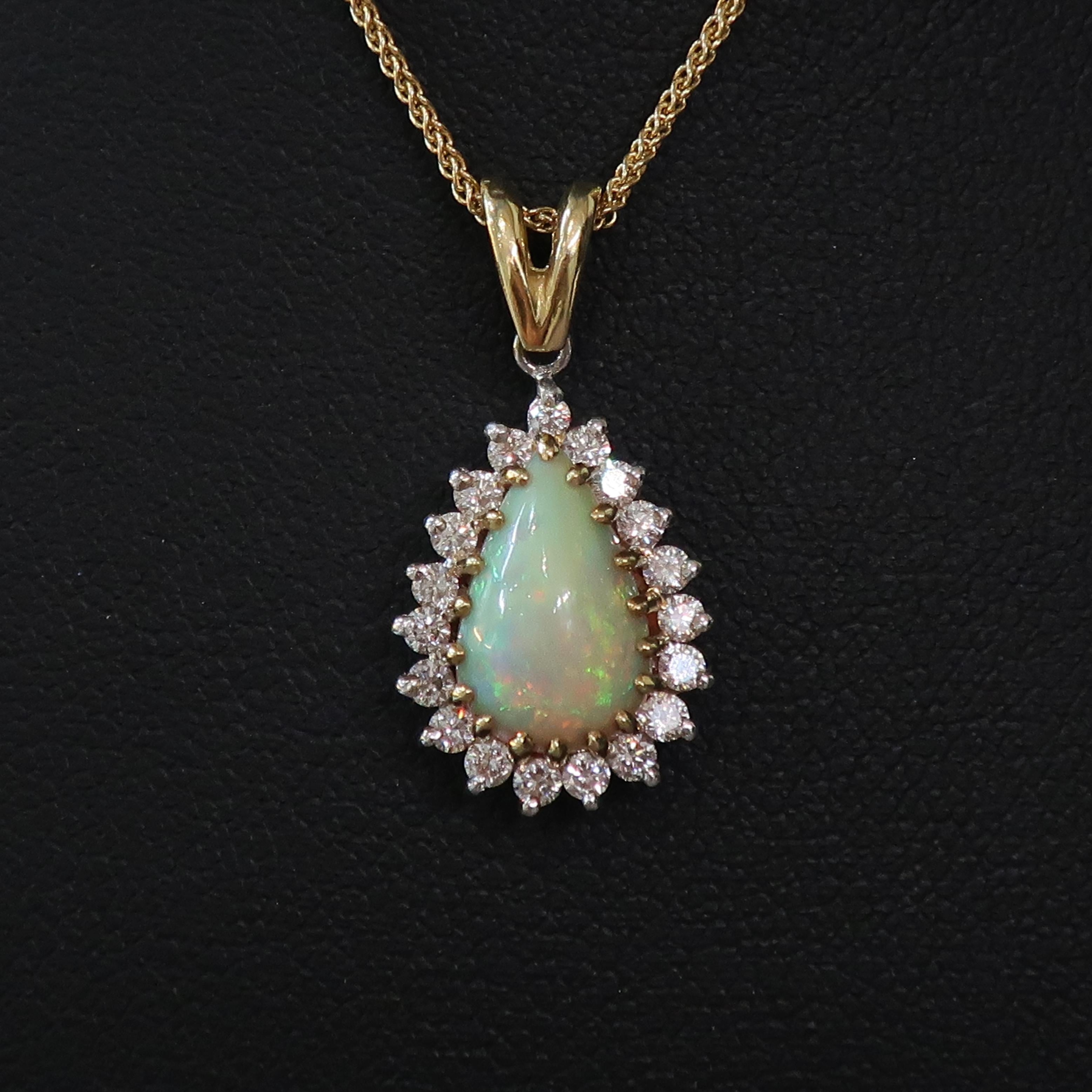 Pear Shape Opal & Diamond Cluster Pendant 18 Karat Yellow and White Gold

A dazzling opal and diamond pendant. Cabochon pear shaped opal set in 18carat yellow gold claws, surrounded by nineteen white brilliant cut diamonds, all claw set in 18ct