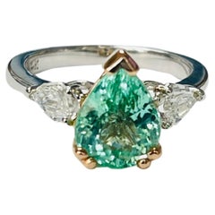 Anillo de compromiso de oro blanco con diamantes y paraiba en forma de pera.