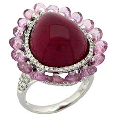 Anello a forma di pera con rubino rosso, zaffiro rosa e diamante bianco aureolato in oro bianco 18 carati