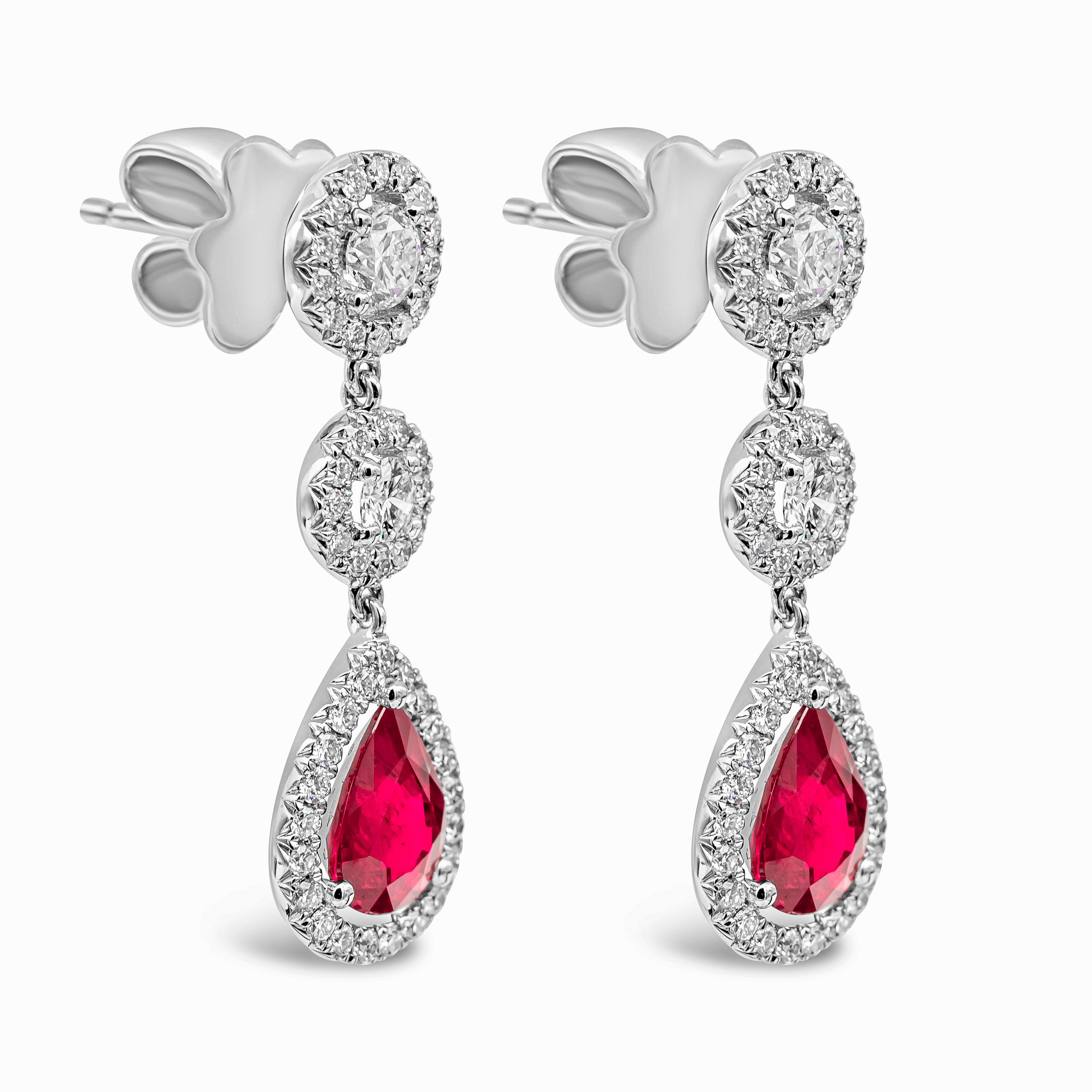 A color-rich pair of dangle earrings showcasing pear shape rubies set in a brilliant diamond halo. Rubies suspended on two diamond halos. Made in 18k white gold. Rubies weigh 2.25 carats total; diamonds weigh 1.13 carats total.

Style available in