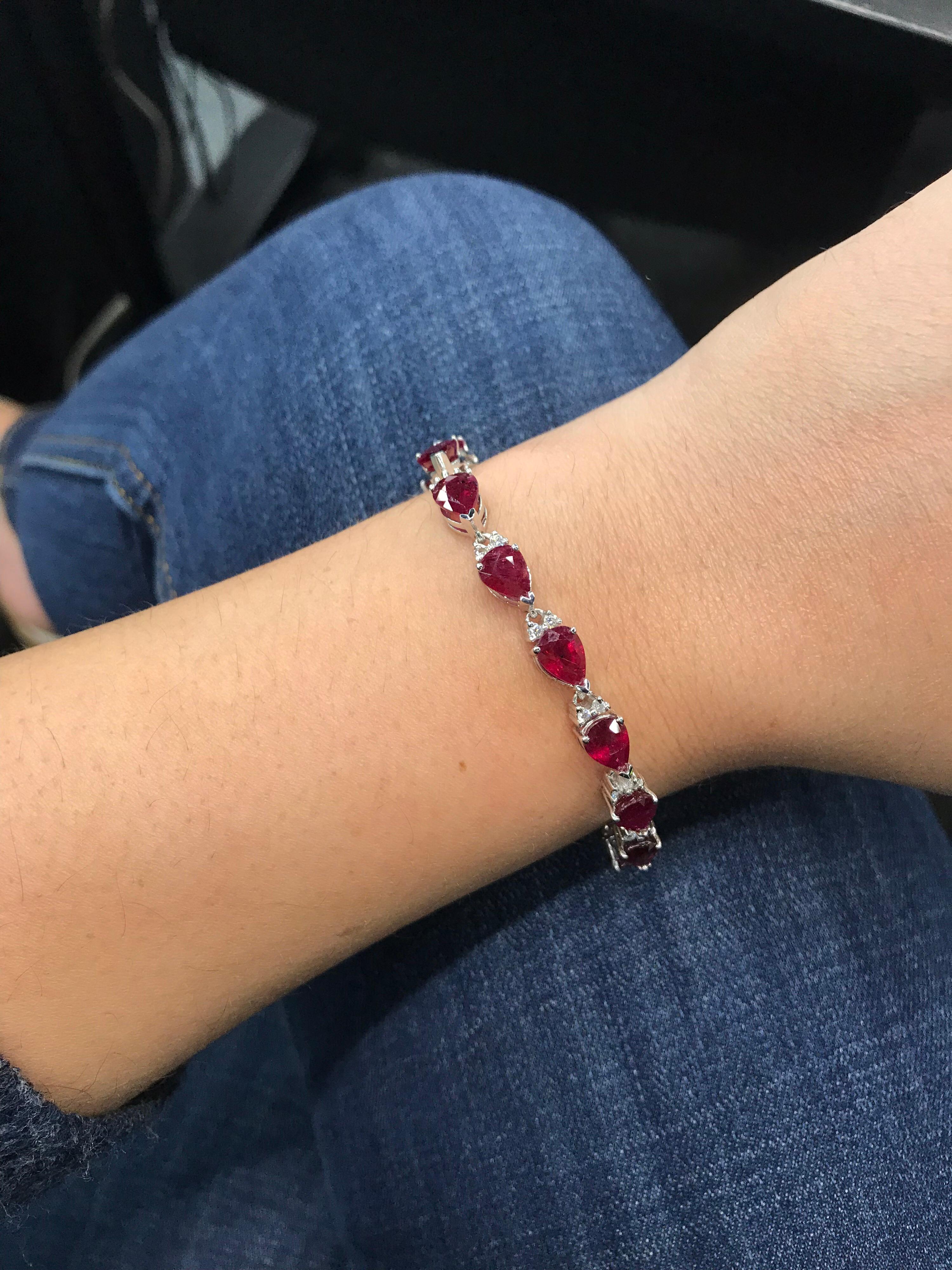 14K White gold tennis bracelet featuring 15 pear shape red rubies, 19.77 carats, with alerternating rounf brilliants weighing 0.90 carats