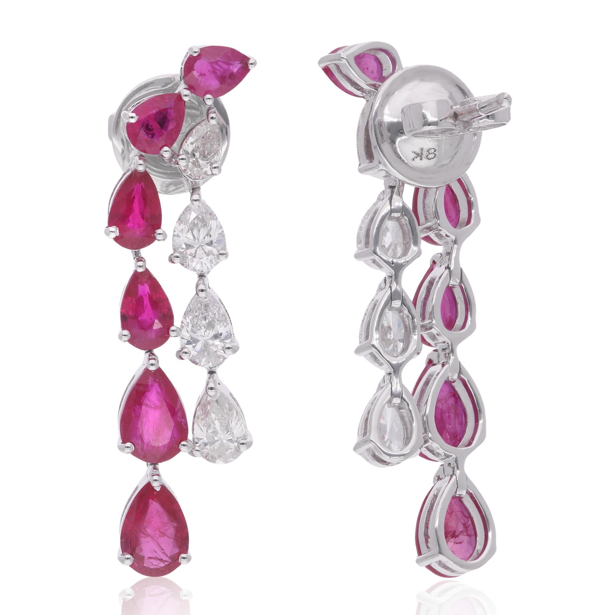 Embrace the allure of elegance with these Pear Shape Ruby Gemstone Dangle Earrings, adorned with diamonds and meticulously crafted in 14 karat white gold. Each earring features a captivating pear-shaped ruby gemstone, renowned for its rich red hue