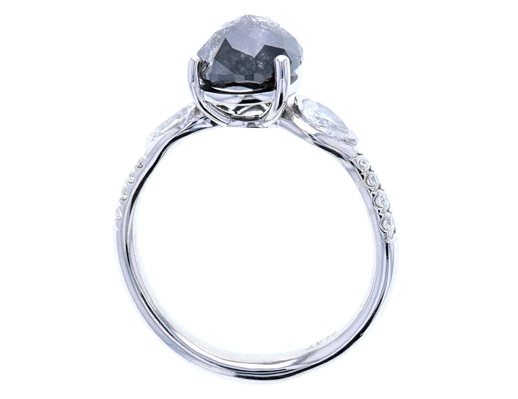 An exquisite pear shaped salt and pepper diamond engagement ring with pear shaped side stones and almost three carats worth of white and black diamond pave. A striking piece crafted in platinum, a custom flush fit, perfect match wedding band was