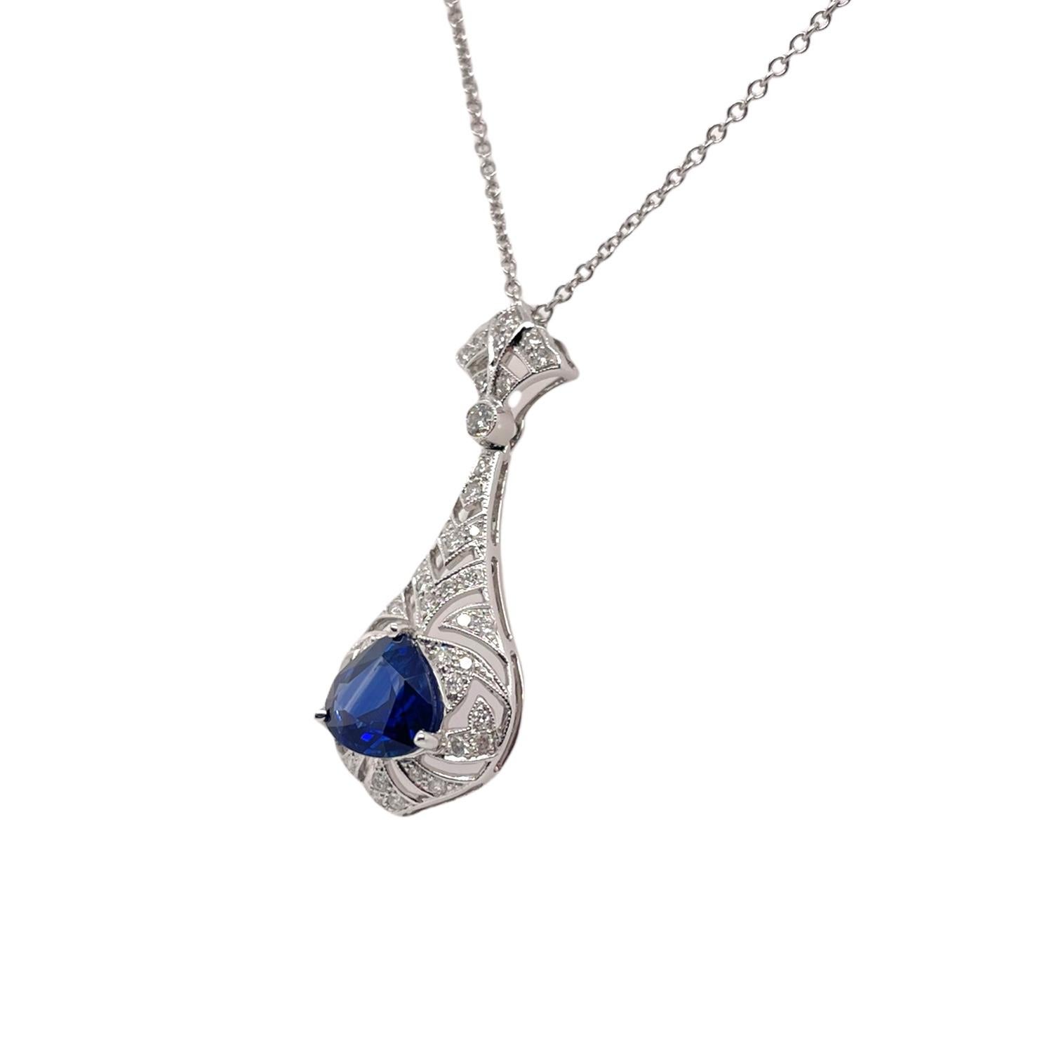 Pendant contains 1 center pear shape sapphire weighing 1.85ct. Center stone is surrounded by an Art Deco style pendant containing 42 round brilliant diamonds, 0.35tcw. Diamonds are near colorless and SI1 in clarity. Total pendant measures