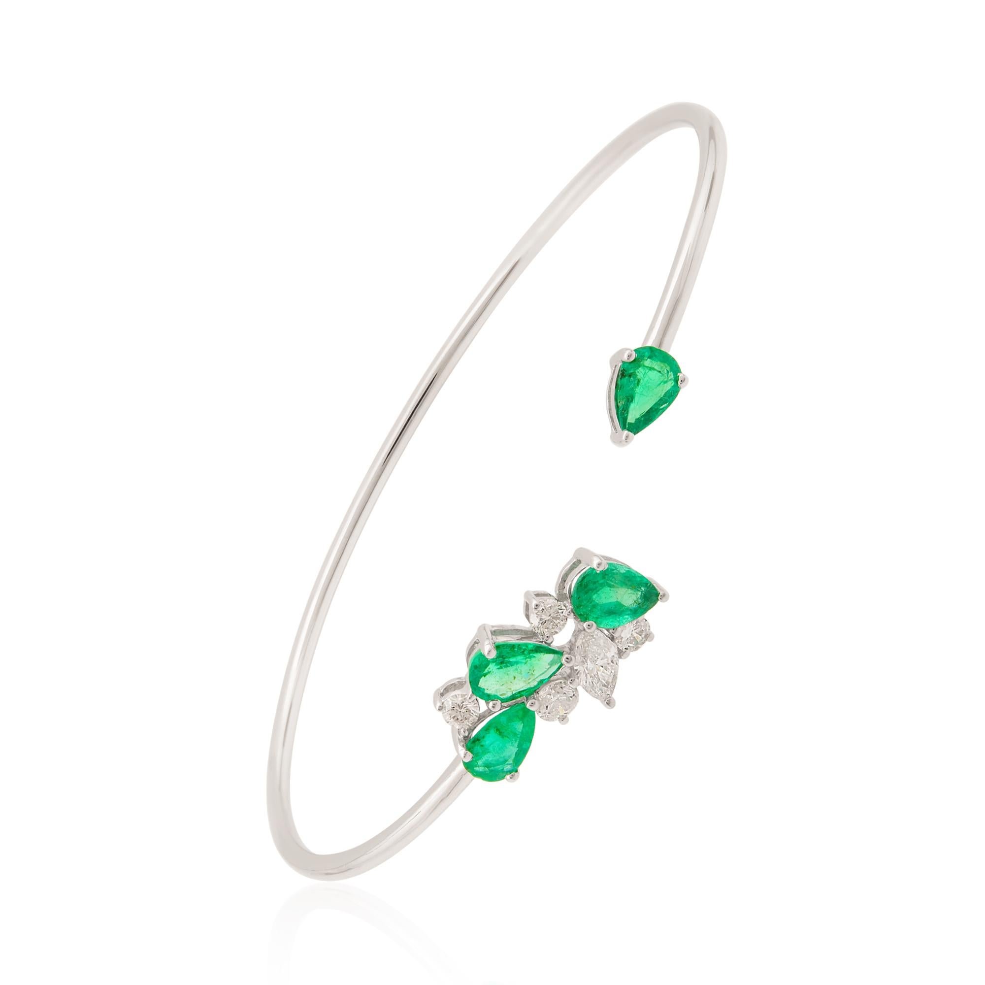 At the heart of this cuff bangle bracelet is a stunning pear-shaped natural emerald gemstone. The emerald displays its mesmerizing green hue, known for its rich and vibrant color that is synonymous with elegance and beauty. The pear shape adds a