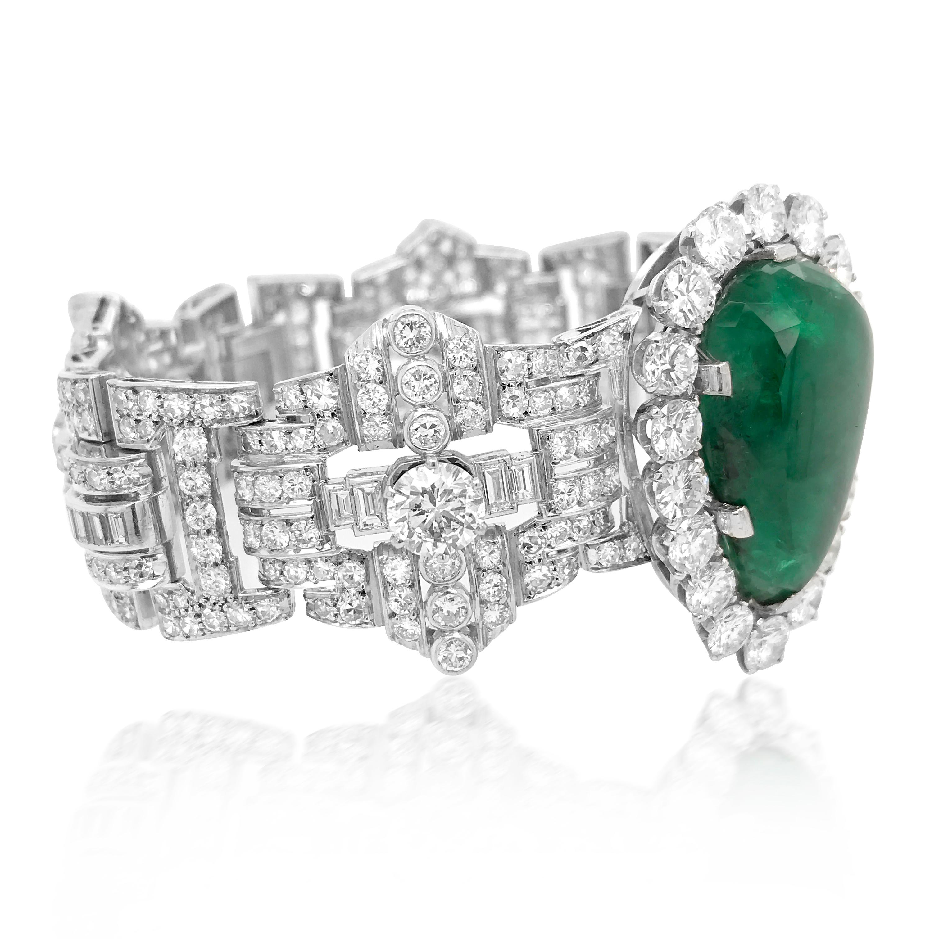 This opulent, quintessentially Retro design bracelet is rendered in solid 18K, weighing 84.77 grams and measuring approx. 19.2 cm (7.55 inches) long and 38mm (1.5 inches) wide. The impressive bracelet is centered with a pear shape cabochon emerald,