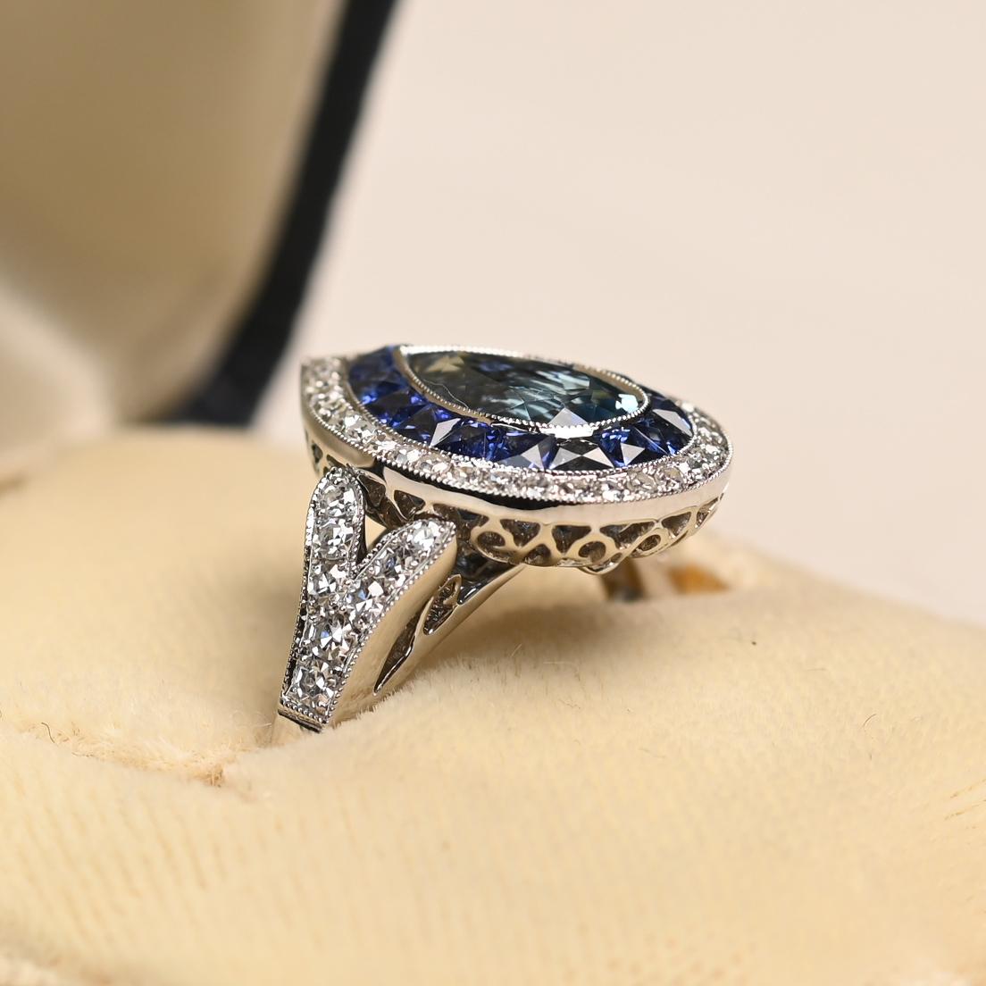 This exquisite ring features a pear-shaped aquamarine of approximately 0.90 carats, displaying the sought-after Santa Maria blue hue. The aquamarine is framed by a double halo of sapphires and diamonds, creating a vibrant contrast that enhances the