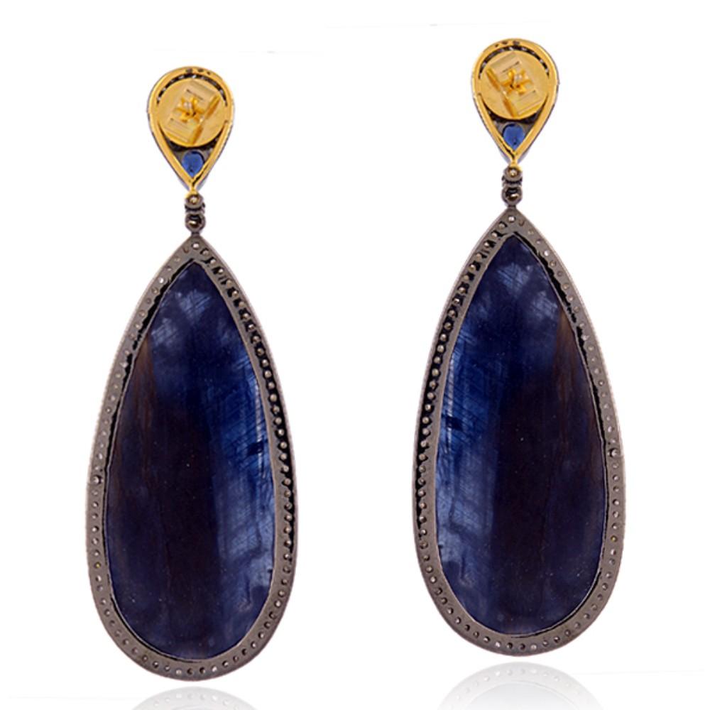 The magnificent blue sapphire gemstones, cut in a perfect pear shape, are the focal point of these stunning earrings, evoking a sense of sophistication and elegance. The intense, deep blue hue of the sapphires is truly mesmerizing and perfectly