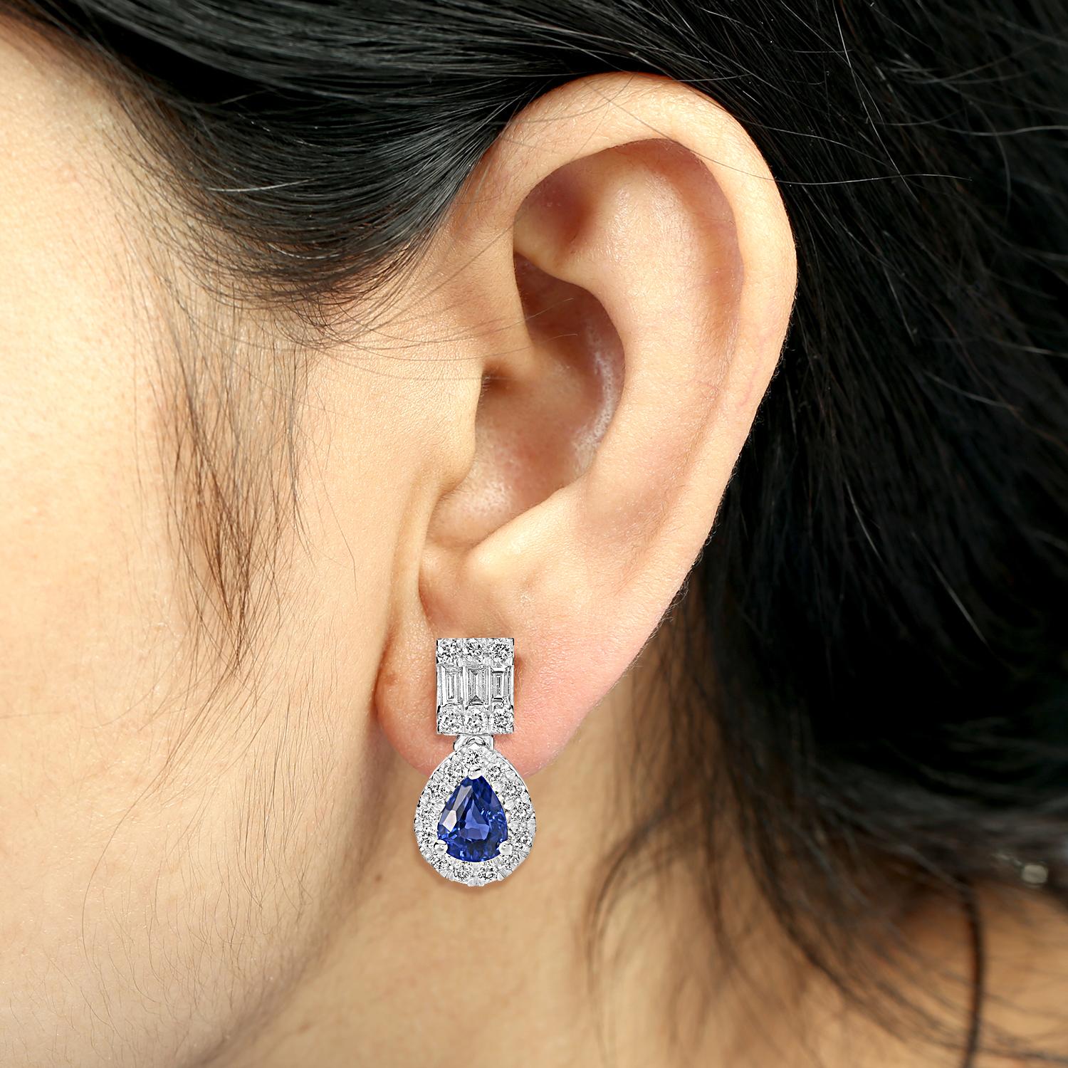Questi eleganti orecchini minimal sono caratterizzati da zaffiri blu di Ceylon a forma di pera incorniciati da delicati diamanti. Realizzato in oro 18 carati, il design bilancia la raffinatezza con l'indossabilità quotidiana, rendendolo un'aggiunta