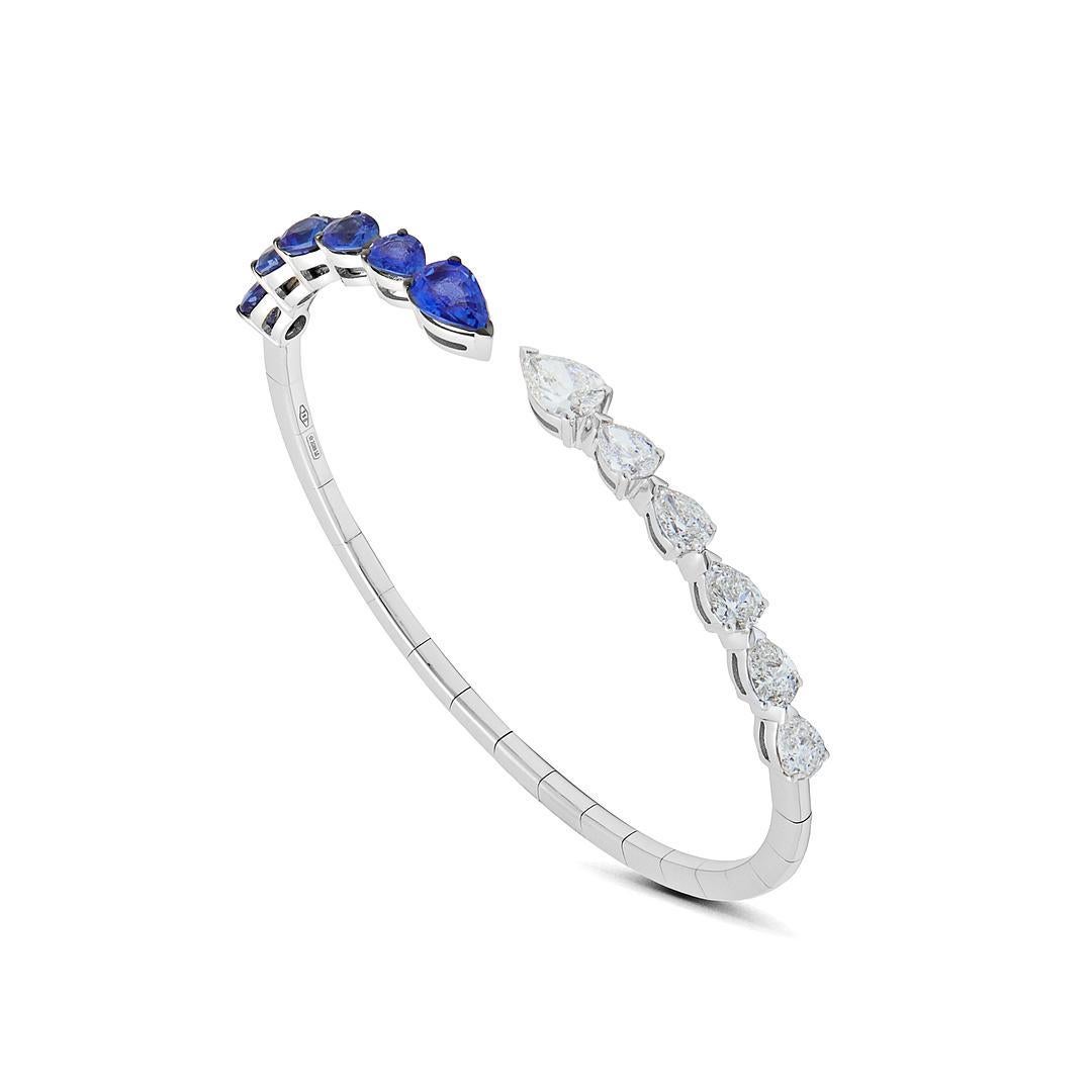 Le bracelet manchette en diamant poire et saphir bleu est une pièce de superposition idéale. Cette élégante manchette ouverte présente des diamants en forme de poire alternant avec des saphirs bleus en forme de poire, ajoutant une touche de couleur