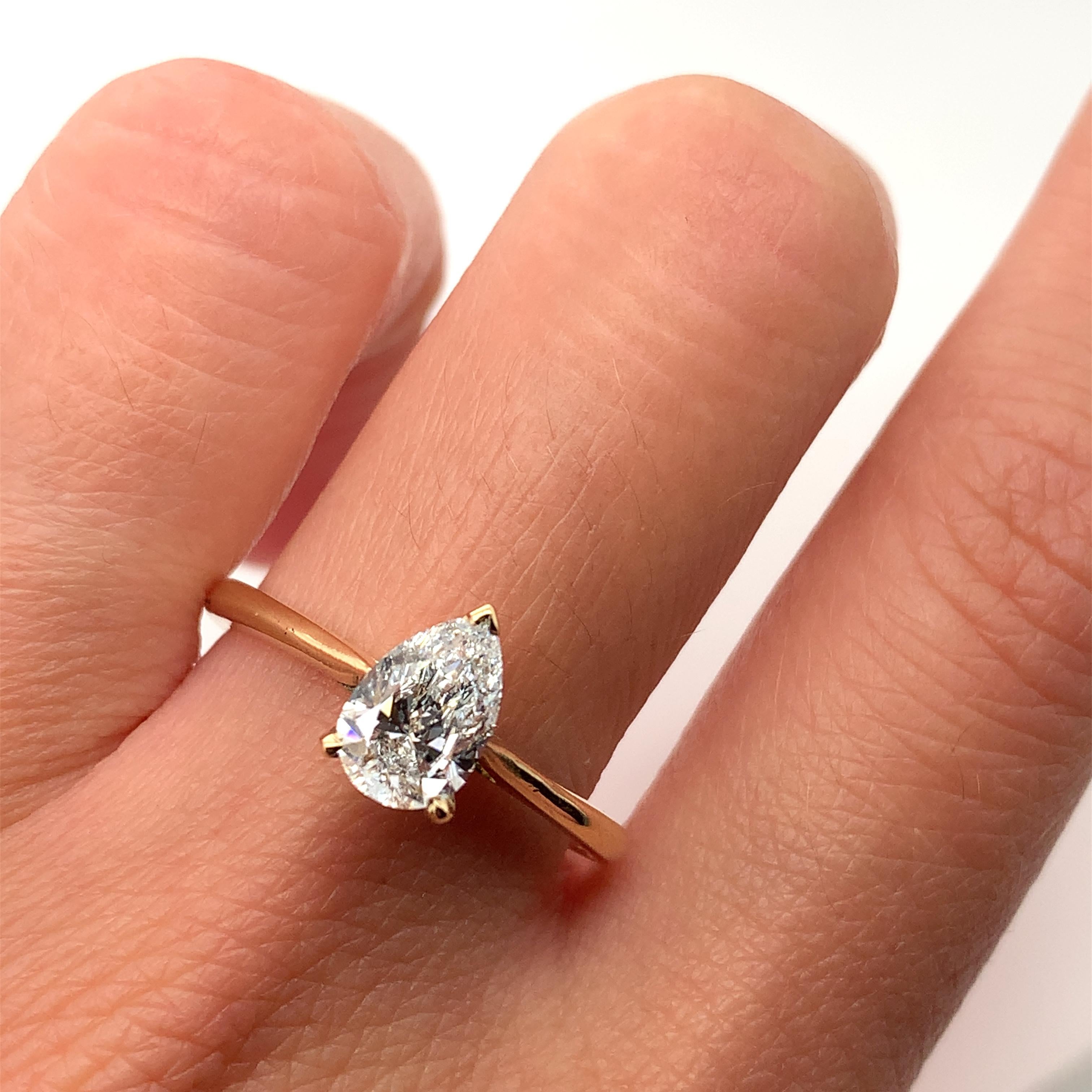 This stunning engagement ring is the perfect choice for anyone who wants to make a statement. Crafted from high-quality 18k yellow gold, this ring features a beautiful pear-shaped diamond that sparkles in the light. The solitaire setting style adds